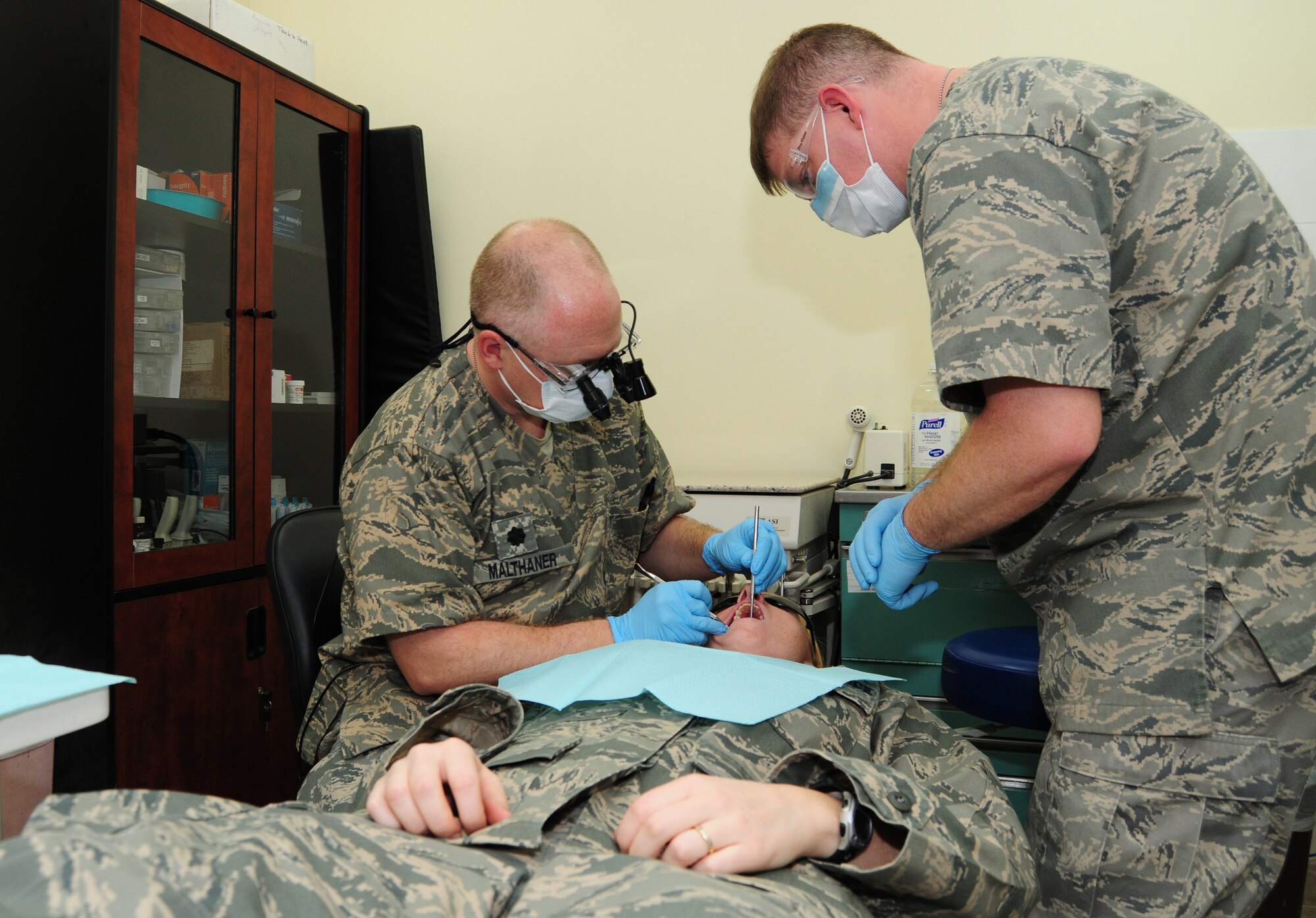 U.S. Air Force Lt. Col. Scott Malthaner, performs a dental examination on a patient as Tech. Sgt. Charles Patterson stands by ready to assist him with instruments, materials or radiographs Feb. 15, 2010 at an air base in Southwest Asia. Colonel Malthaner and Sergeant Patterson, both of the 386th Expeditionary Medical Group are deployed from Wright-Patterson Air Force Base, Ohio, where they are part of the 2009 Air Force Medical Service Large Dental Clinic Team of the Year. (U.S. Air Force photo by Staff Sgt. Lakisha A. Croley/Released)  