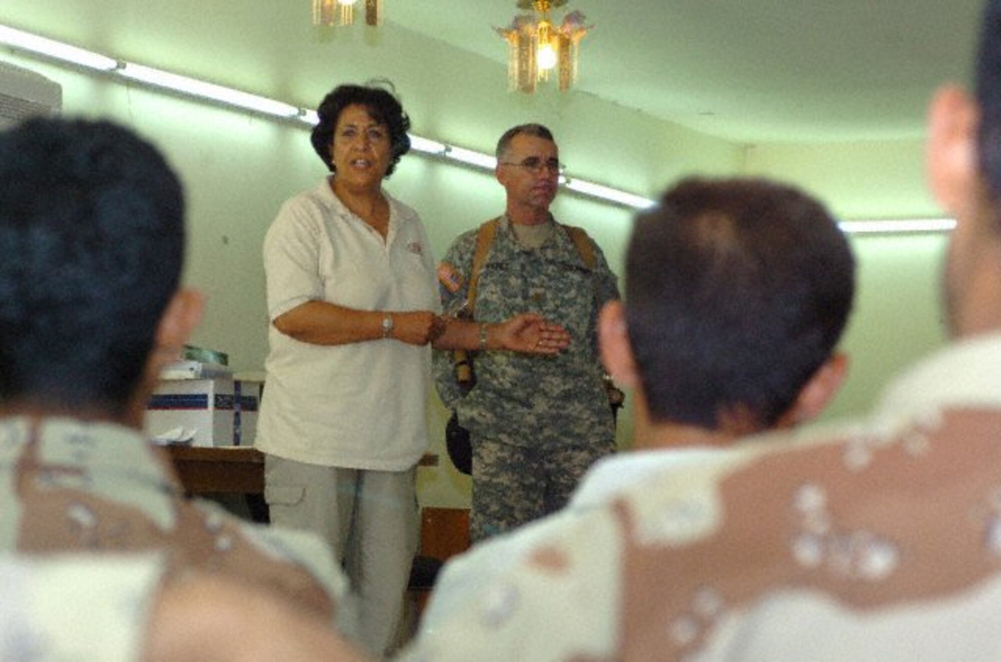 Dr. Ahlam Turki, Basic Medical Clinic Assistant Course instructor and Baghdad native, translates as Army Maj. Alberto Perez, preventive medicine officer, 358th Civil Affairs Brigade, congratulates a group of Iraqi army soldiers during their graduation ceremony. Perez, a Puerto Rico native, said sixteen troops completed the course as part of the first class held for the IA, held at the Community Military Outreach Clinic on Victory Base Complex. (U.S. Army photo by Spc. Laura Bigenho) 

