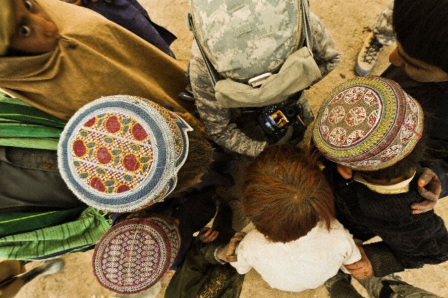 U.S. Air Force Staff Sgt. Christine Jones, a photographer with the 4th Combat Camera Squadron, shows her photographs to Afghan children in Shabila Kalan, Zabul province, Afghanistan. Afghan national army soldiers and U.S. Soldiers from 4th Battalion, 23rd Infantry Regiment, 5th Brigade Combat Team, 2nd Infantry Division are conducting a joint patrol in support of Operation Enduring Freedom. (U.S. Air Force photo by Tech. Sgt. Efren Lopez)

