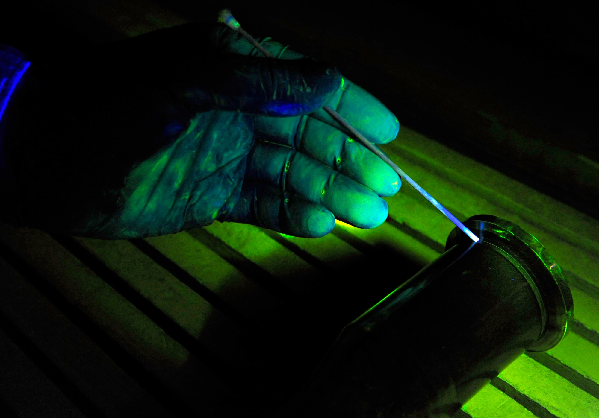 HOLLOMAN AIR FORCE BASE, N.M. -- Staff Sgt. Zachery Doering, 49th Maintenance Squadron non-destructive inspection specialist, uses a swab to point to a crack, illuminated with penetrant, in the main thrust mount pin while performing a magnetic particle inspection at the base NDI shop Feb. 11. A magnetic particle inspection reveals any surface and subsurface defects of magnetic metal items. (U.S. Air Force photo by Senior Airman Tiffany Trojca)