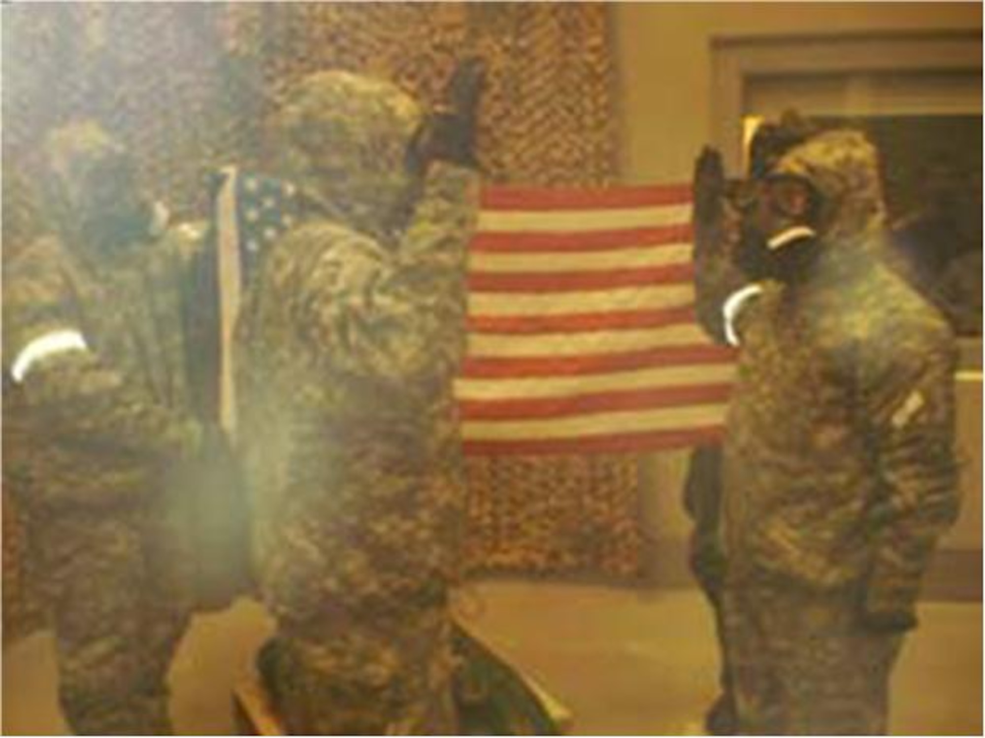 Lt. Col. Michael Sheredy(left), commander 366th Training Squadron Detachment  7, re-enlists Tech. Sgt. Christopher Ackerman(right), an Emergency Management School  instructor at det. 7 while wearing Mission Oriented Protective Posture in the Chemical Defense Training Facility at Fort Leonard Wood, Mo., Dec. 17. The ceremony took place in Bay 7 of the CDTF, where training with a live nerve agent is typically performed. Sergeant Ackerman’s re-enlistment marked the first time for an Air Force member to re-enlist in the "hot area" since it first opened its doors in September 1999. (U.S. Air Force photo courtesy)
