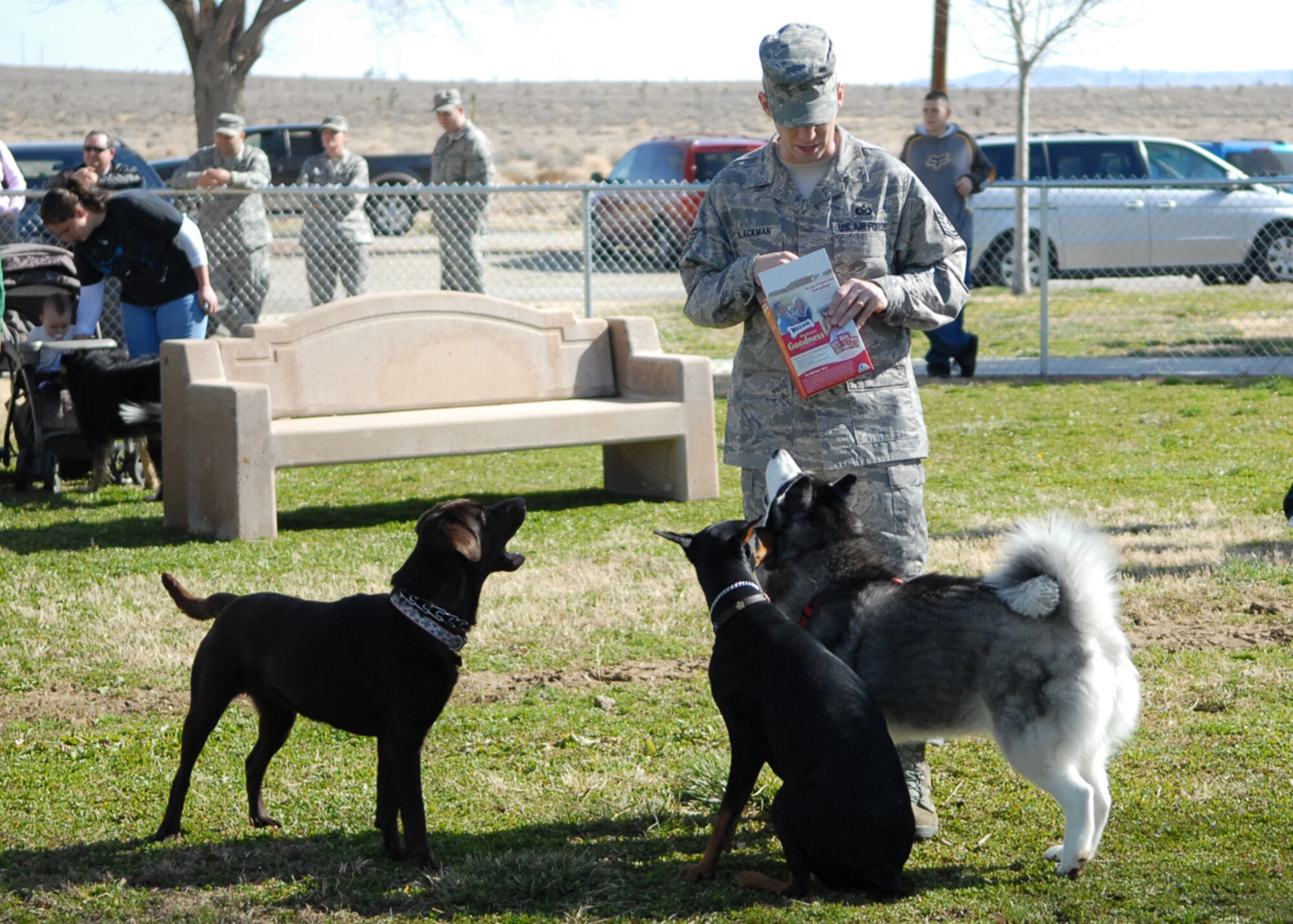 Tech. Sgt. Steven Blackman, 412th Test Wing command chief master sergeant executive assistant, gives treats to dogs during the grand opening of Edwards Bark Park Feb. 12. The park offers base residents a unique amenity, which enhances the quality of life for base residents and their pets. (Air Force photo/Airman 1st Class William O'Brien)