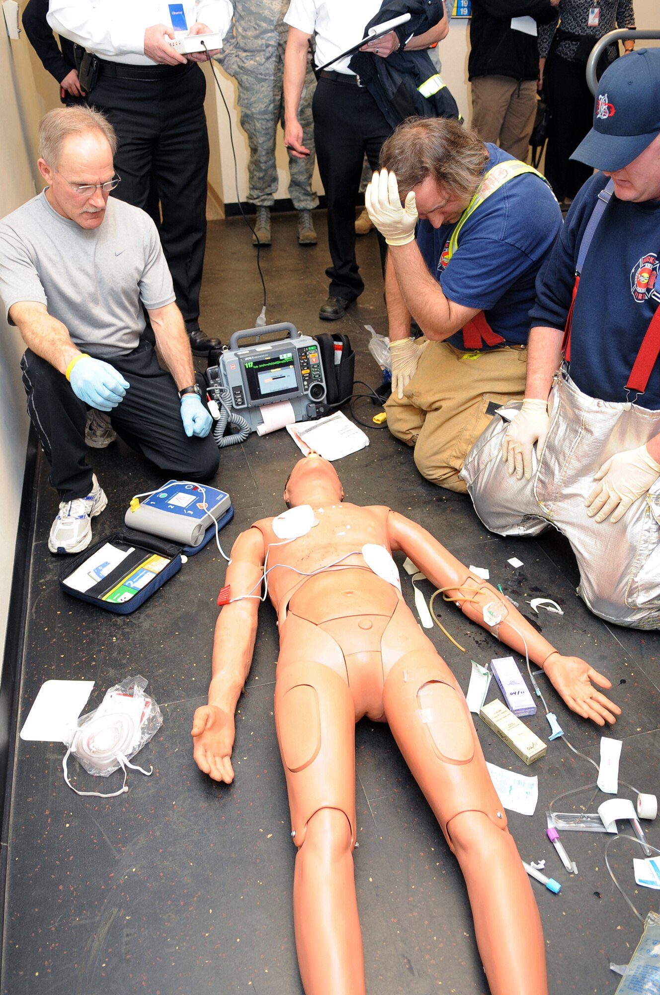 BUCKLEY AIR FORCE BASE, Colo. -- Buckley firefighters stand clear to administer a defibulator shock to a training dummy Feb. 16 as Team Buckley prepares for the upcoming Operational Readiness Inspection. ( U.S. Air Force Photo by Airman 1st Class Marcy Glass )
