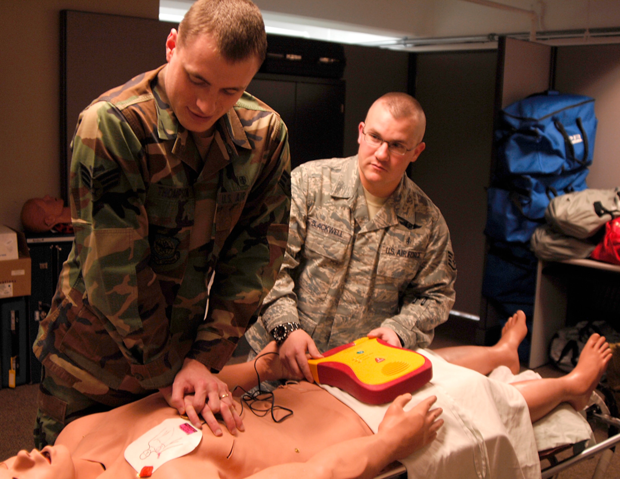 Senior Airman Greyson Thompson, a 22nd Medical Operations Squadron education and training coordinator, and Staff Sgt. Daniel Blackwell, a medical readiness clinic NCOIC and emergency medical technician trainer, demonstrate how to use an automated external defibrillator during a cardiopulmonary resuscitation class at the base clinic, Feb. 17, 2010, at McConnell Air Force Base, Kan. Active-duty servicemembers and civilians employees here can sign up for free CPR classes, held twice per month at the base clinic. For more information on CPR classes, call the clinic at 316-759-5904. (U.S. Air Force photo/Senior Airman Jessica Lockoski) 