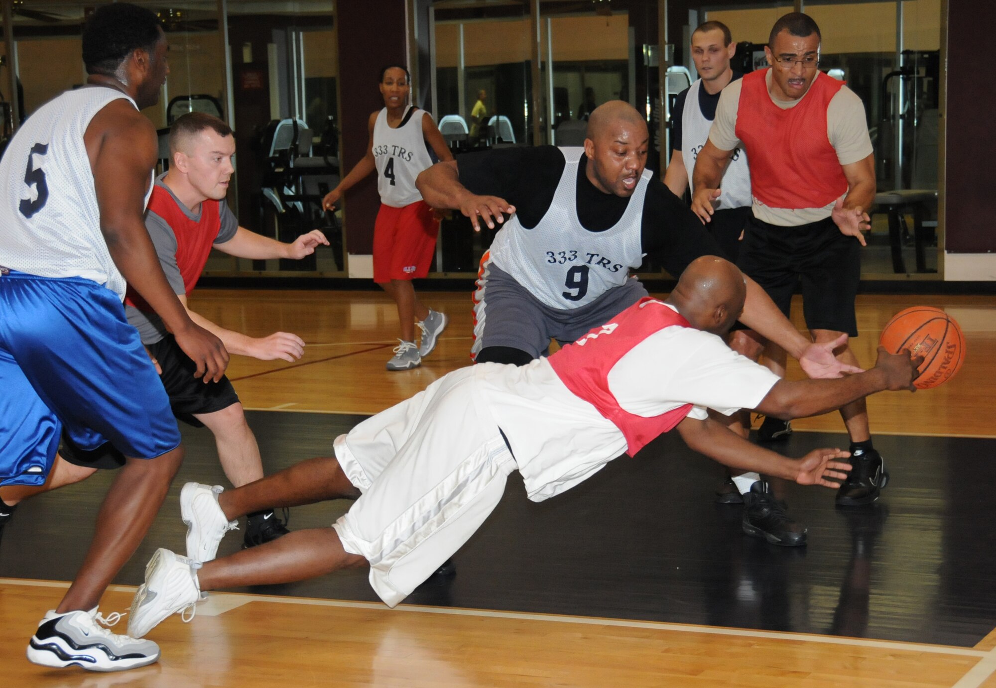 As Dennis Brigman, 81st FSS-CPTS, dives for the ball in the foreground, he’s flanked by (from left) Jason Washington, Jason Guy, Tomeika Washington, Ed Simpson, Gary Hutcheson and Lonnie Slater during the final postseason game between the 81st FSS-CPTS and 333rd TRS.  Jason and Tomeika Washington, Simpson and Hutcheson played for the Mad Ducks and Guy and Slater were members of the 81st FSS-CPTS team.  The 81st FSS-CPTS won the final game, 50-26, to earn the Over-30 basketball championship.  (U.S. Air Force photo by Kemberly Groue)