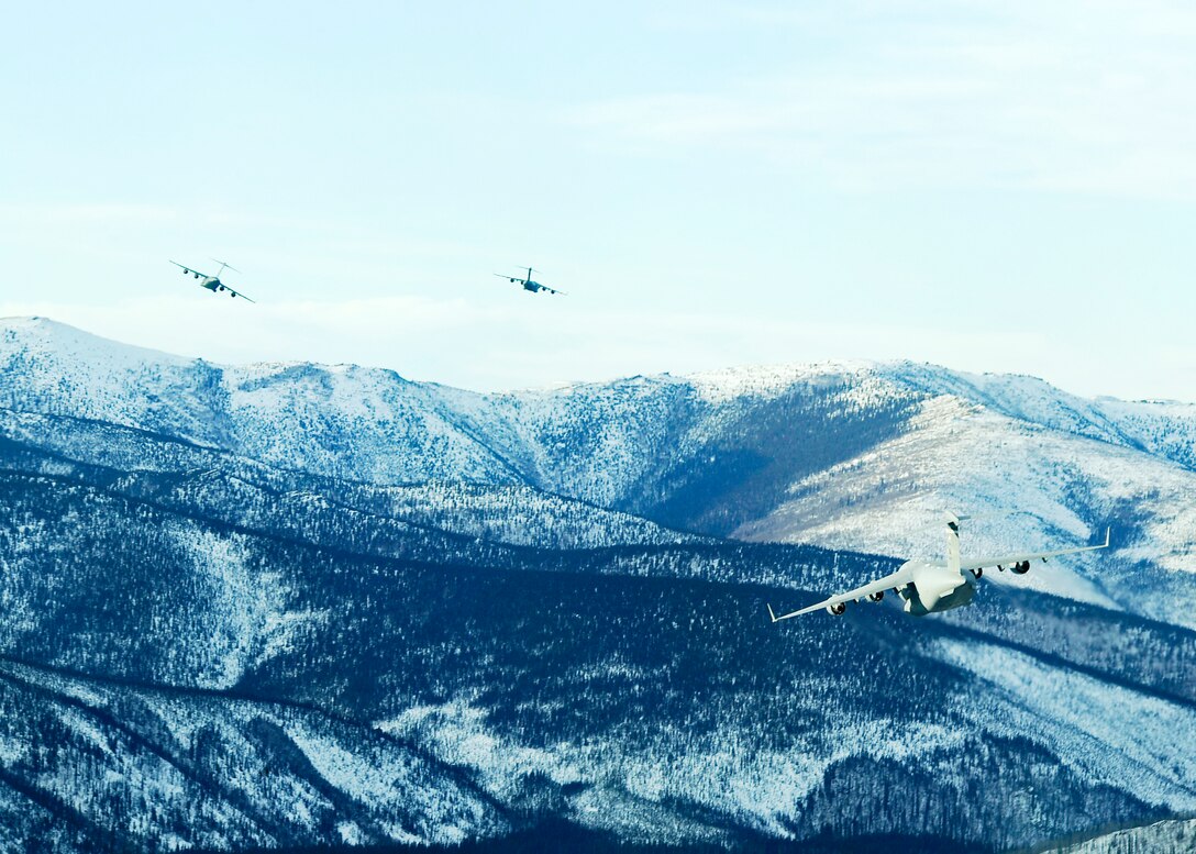 C-17 Globemaster IIIs from the Pacific Air Forces and Air Mobility Command soar over Alaskan mountain ranges near Fort Greely, Alaska, Feb. 10, 2010. The aircraft were participating in an exercise that involved exploring capabilities in large formations and improving tactical awareness among aircrews. (U.S. Air Force photo/Senior Airman Matt Coleman-Foster)