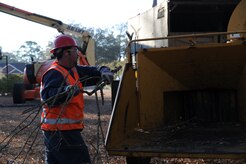 Tyler Huff places branches into a wood chipper on Joint Base Charleston Feb. 17 while performing grounds maintenance. The purpose of using the wood chipper is to keep bulk down and so the branches can later be reused as mulch. Mr. Huff is a member of the landscaping crew that works for Joppa Maintenance Company on the base. (U.S. Air Force photo/Senior Airman Katie Gieratz)(RELEASED)