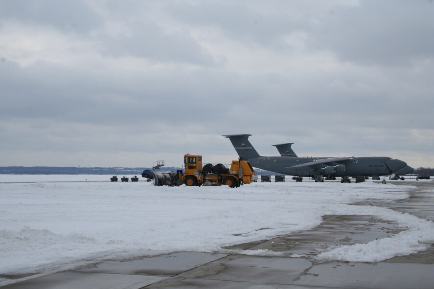 WRIGHT-PATTERSON AIR FORCE BASE, Ohio – Snow plows work their way down the flight line at the 445th Airlift Wing Feb. 17, clearing away the snow surrounding the wing’s C-5 Galaxy aircraft sitting on the ramp after a winter storm brought several more inches of snow to the Dayton, Ohio, area. (U.S. Air Force photo/Stacy Vaughn) 