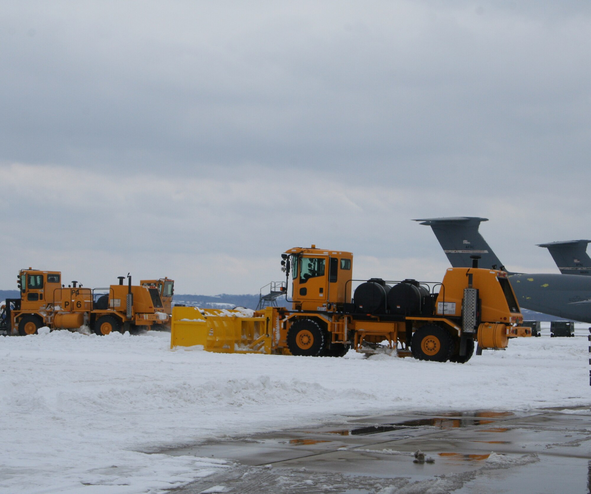 WRIGHT-PATTERSON AIR FORCE BASE, Ohio – Snow plows work their way down the flight line at the 445th Airlift Wing Feb. 17, clearing away the snow surrounding the wing’s C-5 Galaxy aircraft sitting on the ramp after a winter storm brought several more inches of snow to the Dayton, Ohio, area. (U.S. Air Force photo/Stacy Vaughn) 