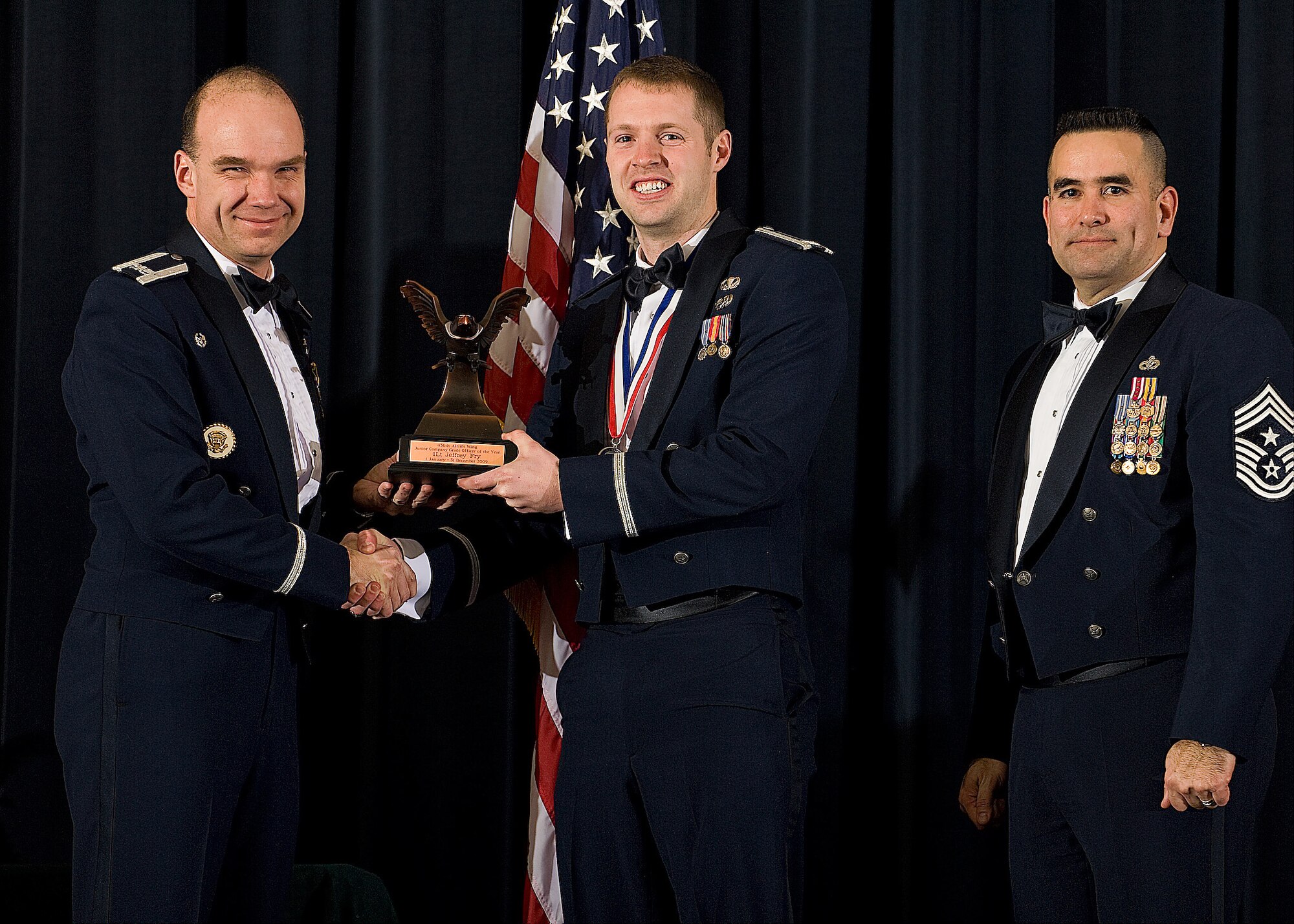(Left) Col. Manson Morris, 436th Airlift Wing commander, and Chief Master Sgt. John Evalle, 436th AW command chief, present 1st Lt. Jeff Fry, 736th Aircraft Maintenance Squadron, with the award for Junior Company Grade Officer of the Year during the Annual Awards ceremony Feb. 12. (U.S. Air Force photo/Roland Balik)