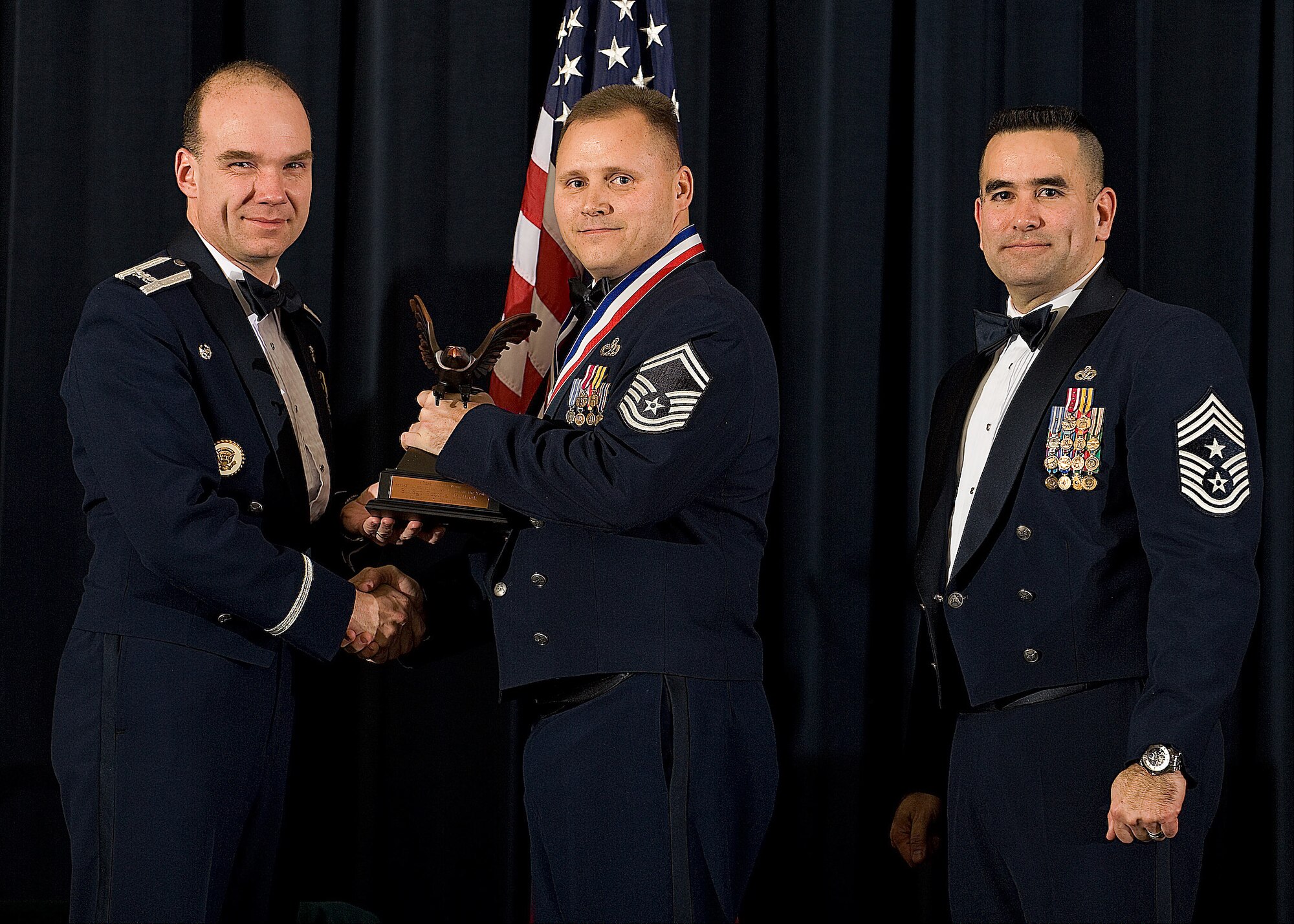 (Left) Col. Manson Morris, 436th Airlift Wing commander, and Chief Master Sgt. John Evalle, 436th AW command chief, present Senior Master Sgt. Scottie Tadlock, 736th Aircraft Maintenance Squadron, with the award for Senior Non-commissioned Officer of the Year during the Annual Awards ceremony Feb. 12. (U.S. Air Force photo/Roland Balik)