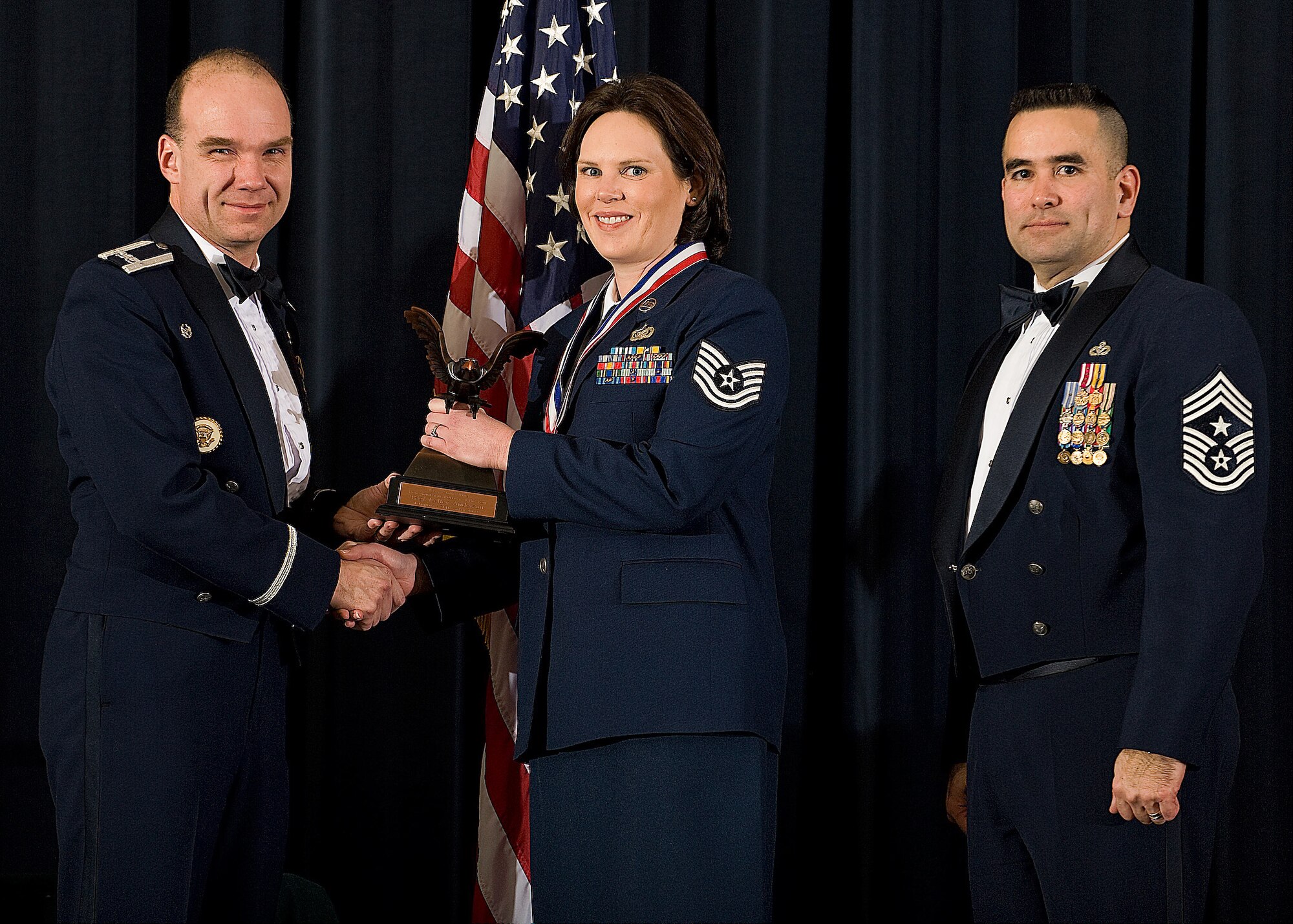 (Left) Col. Manson Morris, 436th Airlift Wing commander, and Chief Master Sgt. John Evalle, 436th AW command chief, present Tech. Sgt. Kelley Anderson, 436th AW, with the award for Non-commissioned Officer of the Year during the Annual Awards ceremony Feb. 12. (U.S. Air Force photo/Roland Balik)