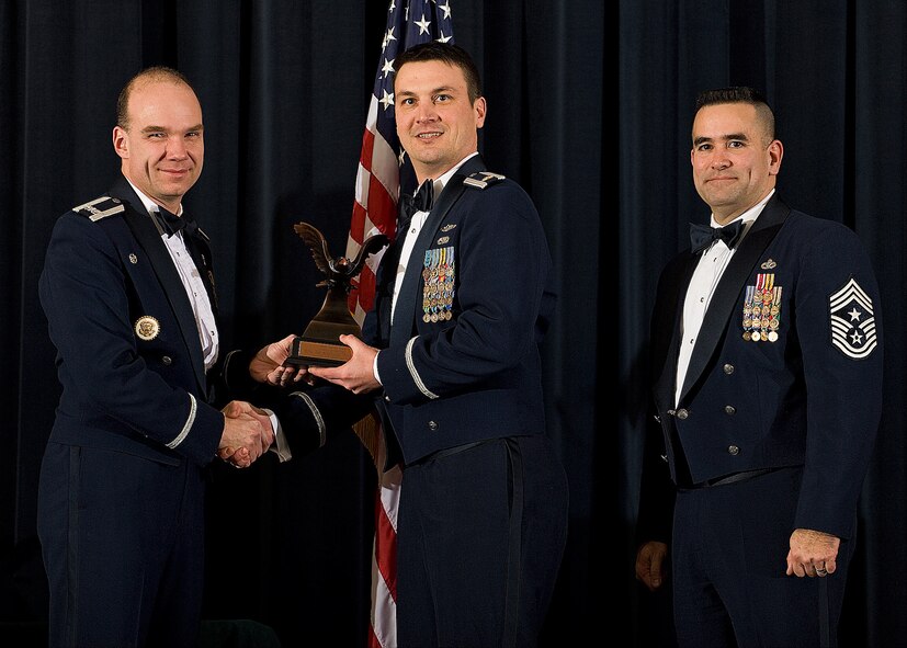 (Left) Col. Manson Morris, 436th Airlift Wing commander, and Chief Master Sgt. John Evalle, 436th AW command chief, present Maj. Jimmy Arnold, 436th Logistics Readiness Squadron, with the award for Airman of the Year during the Annual Awards ceremony Feb. 12. Major Arnold was accepting on behalf of Senior Airman Keyshondra Pringle, 436th LRS, who is currently deployed. (U.S. Air Force photo/Roland Balik)