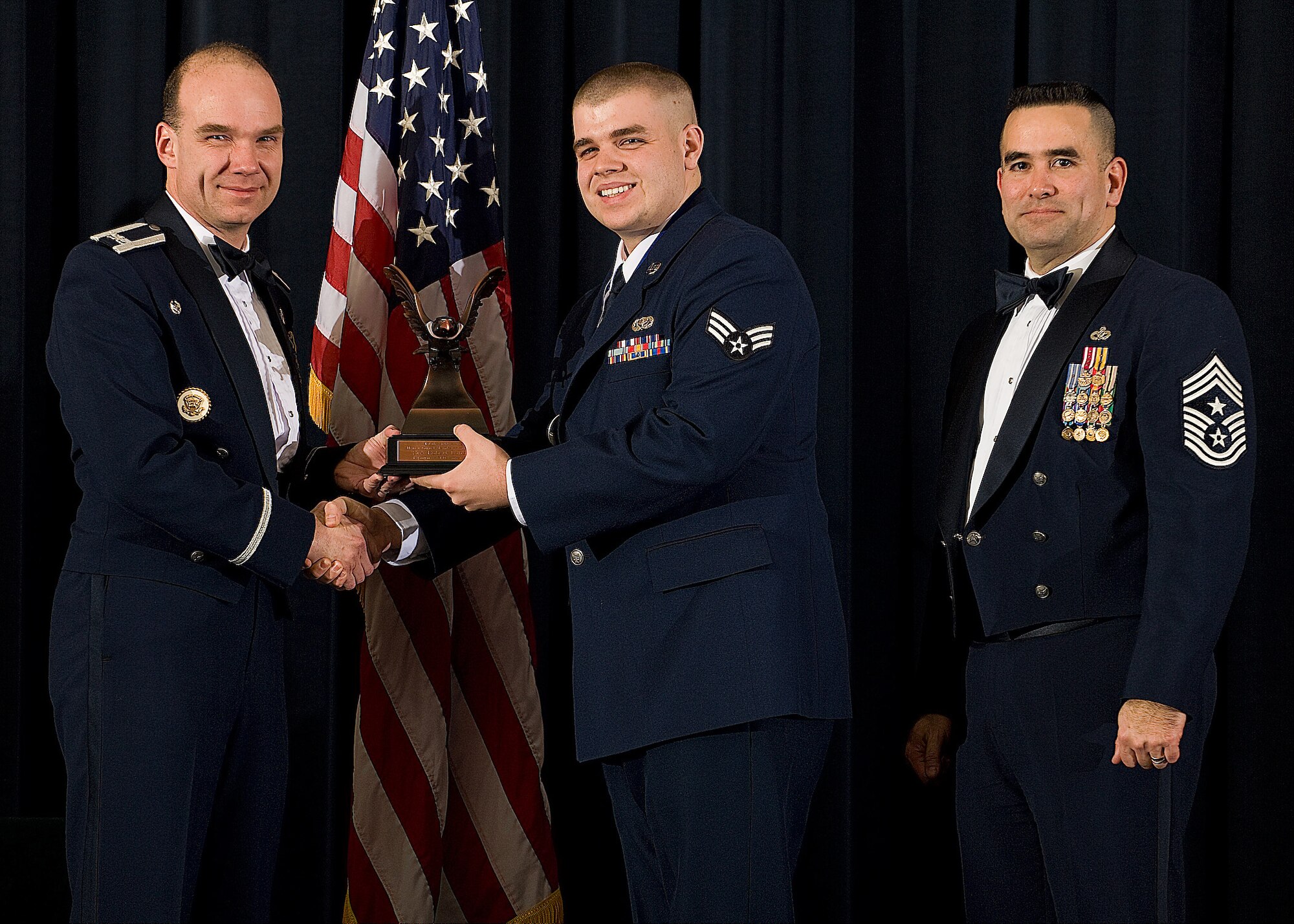 (Left) Col. Manson Morris, 436th Airlift Wing commander, and Chief Master Sgt. John Evalle, 436th AW command chief, present Senior Airman Robert Landon, 436th Force Support Squadron, with the award for Honor Guard Member of the Year during the Annual Awards ceremony Feb. 12. (U.S. Air Force photo/Roland Balik)