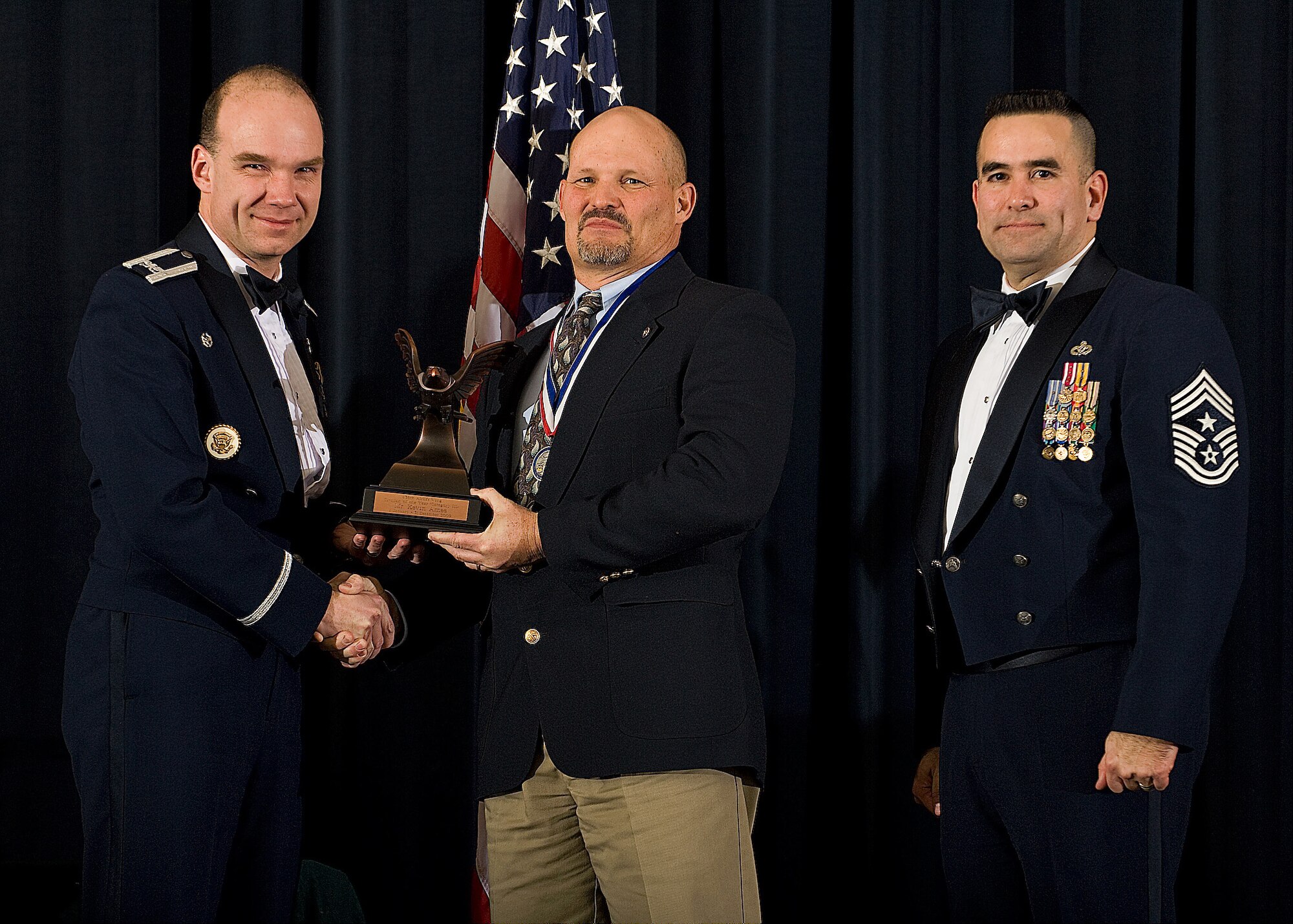 (Left) Col. Manson Morris, 436th Airlift Wing commander, and Chief Master Sgt. John Evalle, 436th AW command chief, present Kevin Ames, 436th Logistics Readiness Squadron, with the award for Category III Civilian of the Year during the Annual Awards ceremony Feb. 12. (U.S. Air Force photo/Roland Balik)