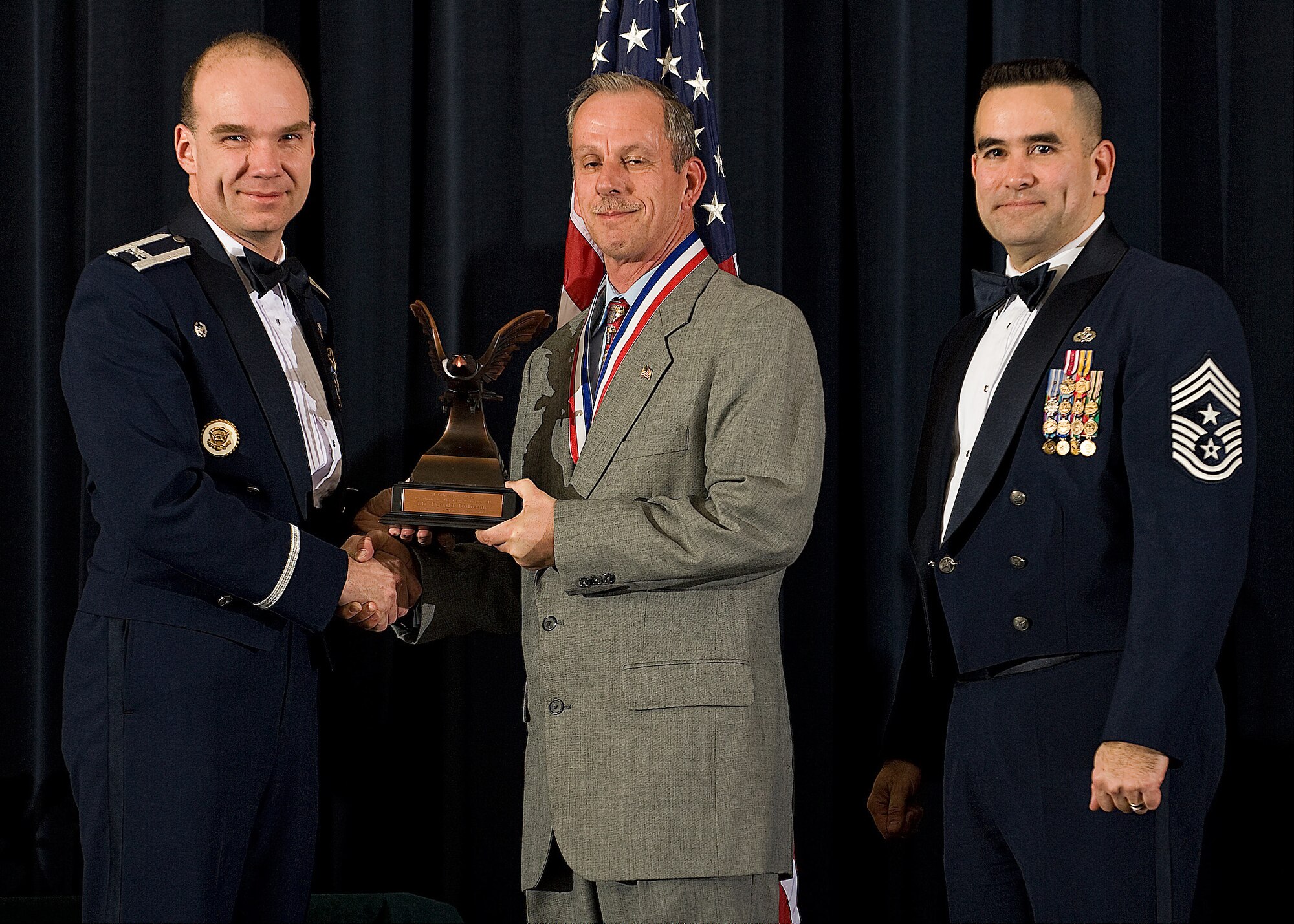 (Left) Col. Manson Morris, 436th Airlift Wing commander, and Chief Master Sgt. John Evalle, 436th AW command chief, present Lucky Dufresne, 436th AW Protocol, with the award for Category I Civilian of the Year during the Annual Awards ceremony Feb. 12. (U.S. Air Force photo/Roland Balik)