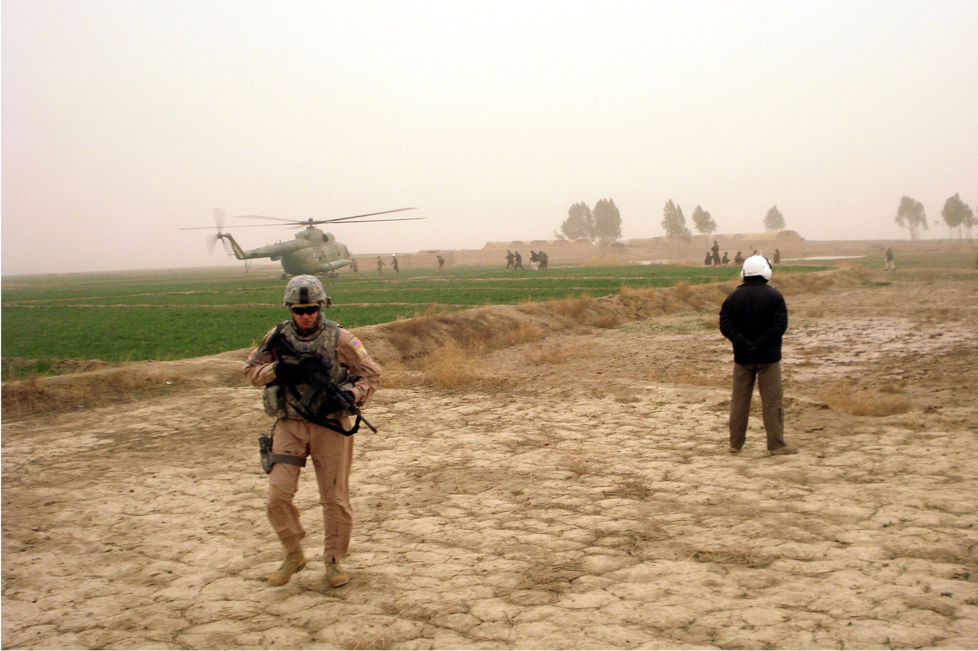 U.S. Air Force and Afghan National Army Air Corps servicemembers provide security as members of the nomadic Kuchi tribe are dropped off at a safe location during a humanitarian rescue mission Feb. 8, 2010, in Kandahar, Afghanistan. Their village, located on a sandbar in the middle of a normally otherwise shallow river, was cut off from the mainland as water levels rose approximately 20 feet deep. (U.S. Air Force photo/Capt. Tyler Rennell)