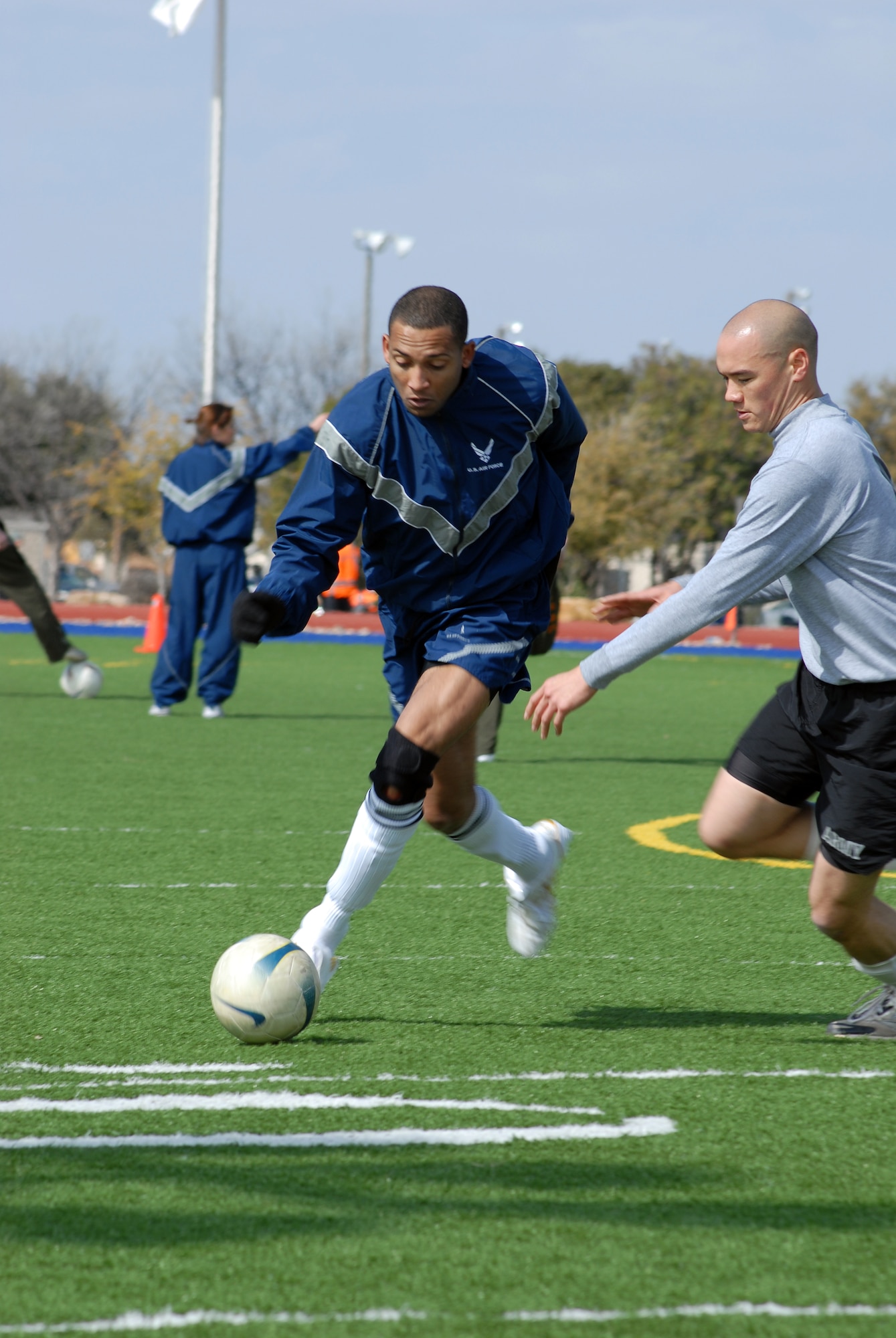Staff Sgt. Damien Patterson, 17th Force Support Squadron, drives the ball past Specialist David Lane, 344th Military Intelligence Battalion, Bravo Company, during a soccer match between Bravo Company and the 17th Training Wing Staff.  Bravo Company went on to win the match 2-0. Goodfellow AFB, Texas took the day to hold multiple sporting events, including volleyball, tennis, and dodge ball, with each unit competing for commander’s cup points.  (U.S. Air Force photo/Master Sgt. Randy Mallard)