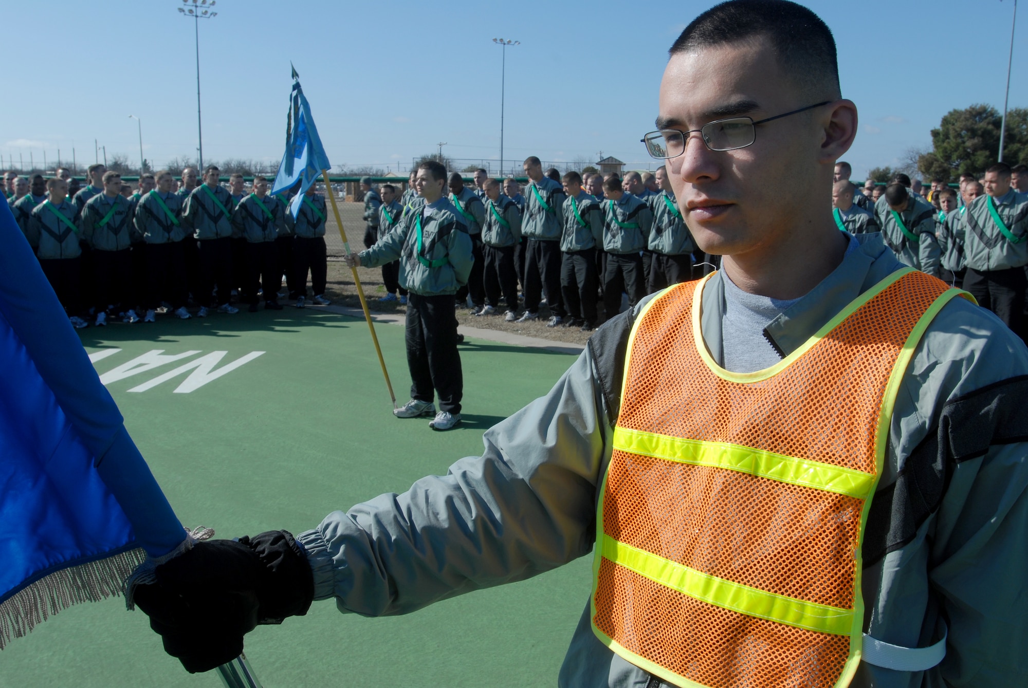 Specialist Carlos Draffin acts as guidon for a formation of soldiers from the 344th Military Intelligence Squadron prior to the start of the 17th Training Wing Sports Day on Feb. 12.  Goodfellow AFB, Texas took the day to hold multiple sporting events, including volleyball, tennis, and dodge ball, with each unit competing for commander’s cup points.  (U.S. Air Force photo/Master Sgt. Randy Mallard)