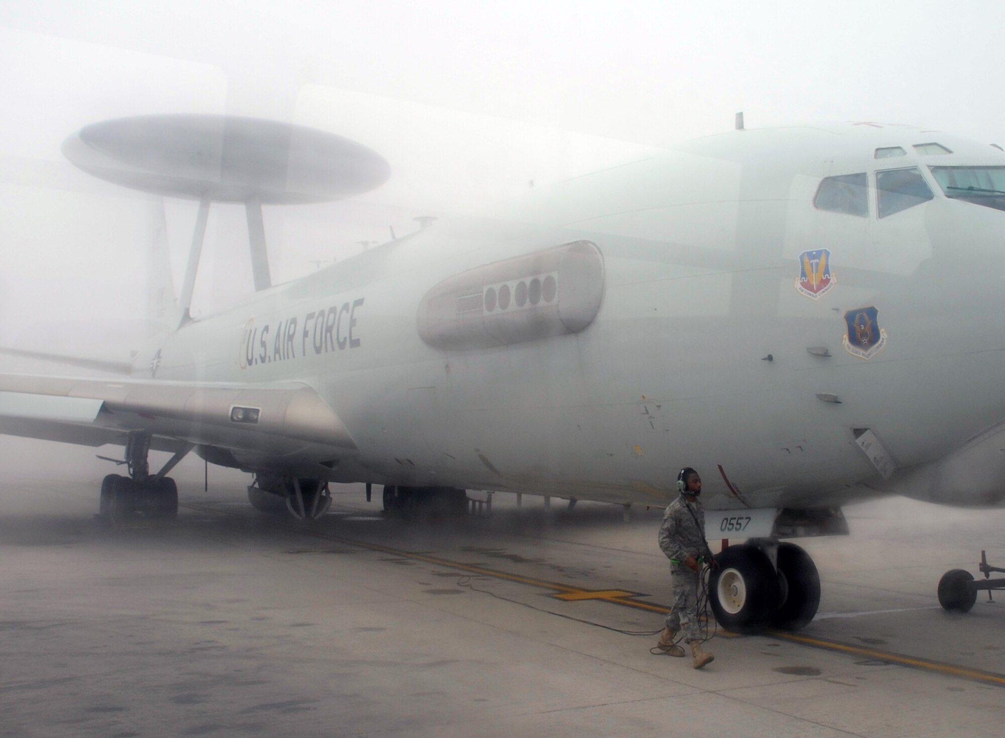 A maintenance Airman inspects an E-3 Sentry Airborne Warning and Control System aircraft that is shrouded by fog on the flightline of the 380th Air Expeditionary Wing at a non-disclosed base in Southwest Asia on Feb. 16, 2010. The E-3, which is assigned to the 965th Expeditionary Airborne Air Control Squadron, is deployed from Tinker Air Force Base, Okla.  The 380th AEW supports operations Iraqi Freedom and Enduring Freedom and the Combined Joint Task Force-Horn of Africa.  (U.S. Air Force Photo/Master Sgt. Scott T. Sturkol/Released)