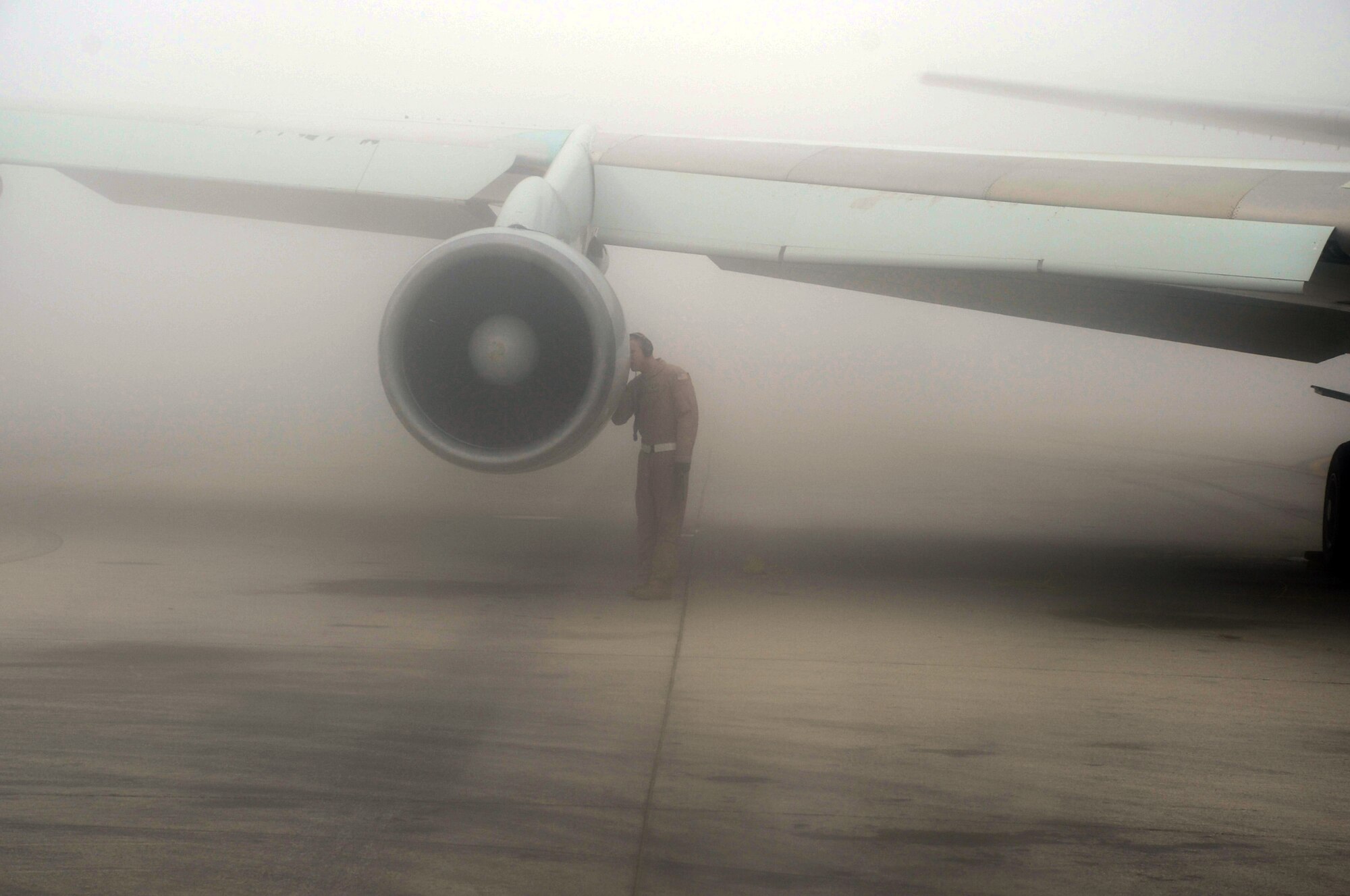 An flight crew members inspects an engine of an E-3 Sentry Airborne Warning and Control System aircraft that is shrouded by fog on the flightline of the 380th Air Expeditionary Wing at a non-disclosed base in Southwest Asia on Feb. 16, 2010. The E-3, which is assigned to the 965th Expeditionary Airborne Air Control Squadron, is deployed from Tinker Air Force Base, Okla.  The 380th AEW supports operations Iraqi Freedom and Enduring Freedom and the Combined Joint Task Force-Horn of Africa.  (U.S. Air Force Photo/Master Sgt. Scott T. Sturkol/Released)