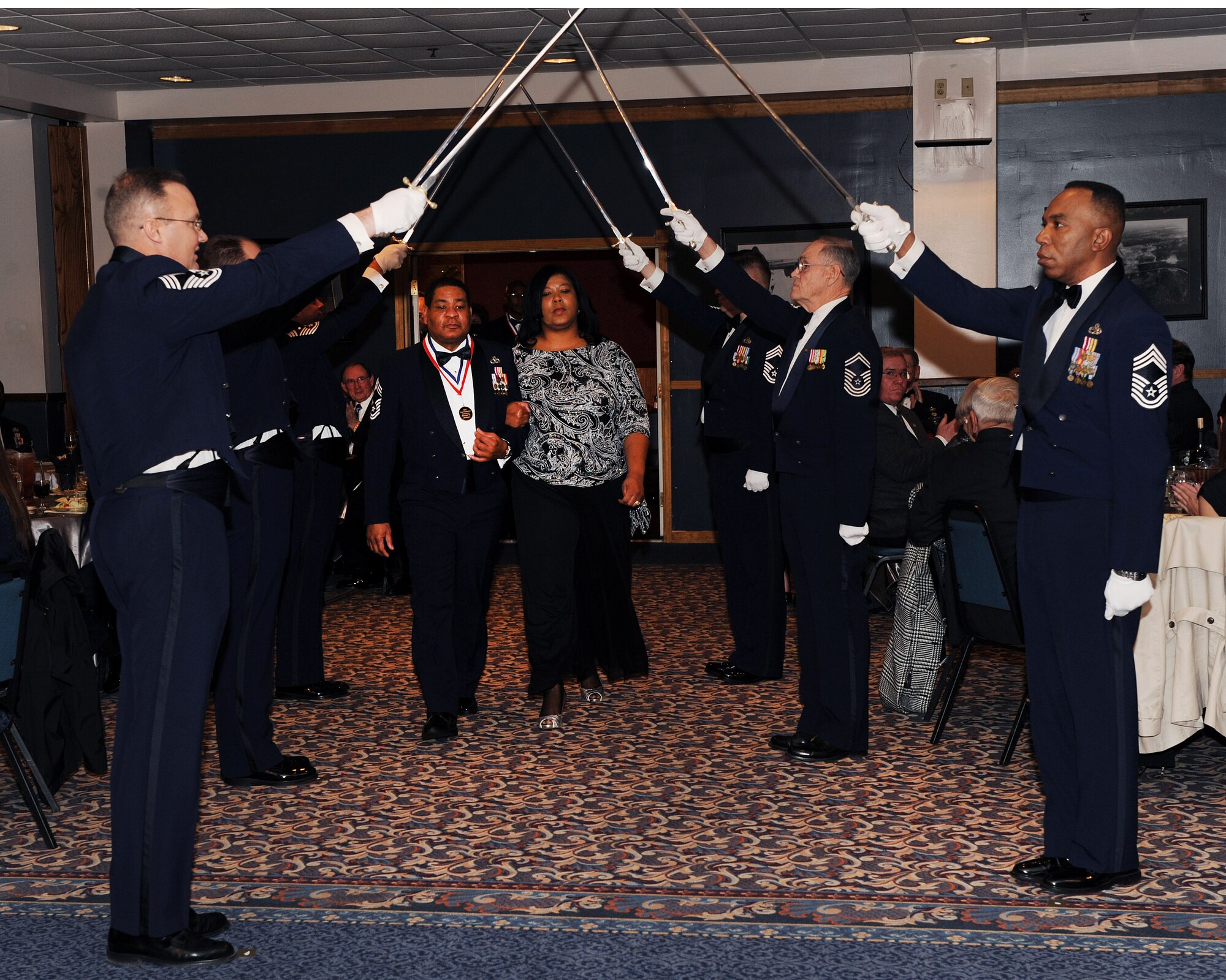 Chief Master Sgt. Ronald Jackson, 189th Maintenance Group equipment chief, and wife, Florence, pass under a saber cordon Feb. 13 during the Annual Chief’s Recognition Ceremony. Fifteen chiefs and chief selects were formally recognized at the banquet highlighting their nomination to the top one percent of the Air Force’s enlisted corps. (U.S. Air Force photo by Staff Sgt. Chad Chisholm)