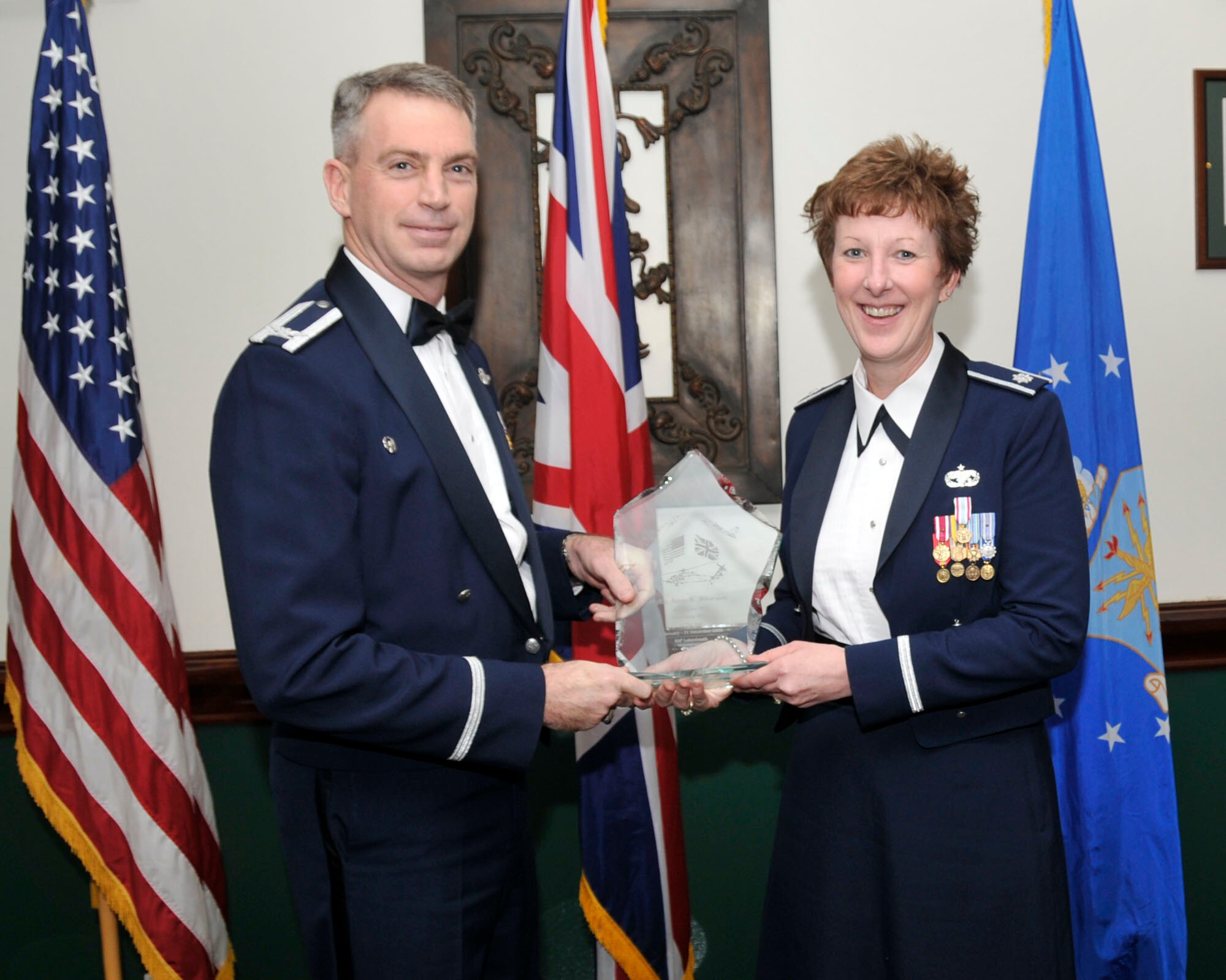 Col. Lawrence Reed, 48th Fighter Wing vice commander (left) and Chief Master Sgt. James Lucas present Col. Debbie Kent 48th Logistics Readiness Squadron commander on behalf of  Maj. Adam G. Silverman, 48th Logistics Readiness Squadron, with the award for Company Grade Officer of the Year at the annual awards at the Eagles Landing Feb 13. (U.S. Air Force photo by Airman 1st Class Eboni Knox)