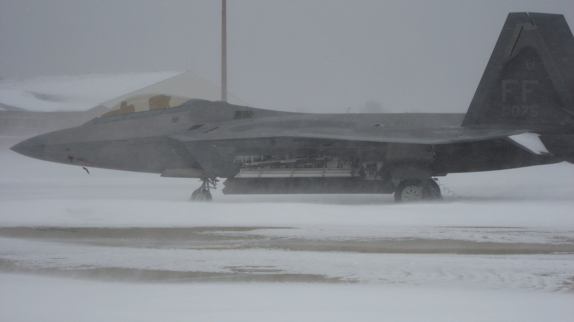 LANGLEY AIR FORCE BASE, Va. – A F-22 Raptor from the 94th Fighter Squadron sits on the flight line during a snow storm Jan. 30. 633d Civil Engineer Squadron crews cleared the airfield within 24 hours after the storm, ensuring continuation of critical homeland security and humanitarian missions. (U.S. Air Force photo/Col. Matt Molloy)
