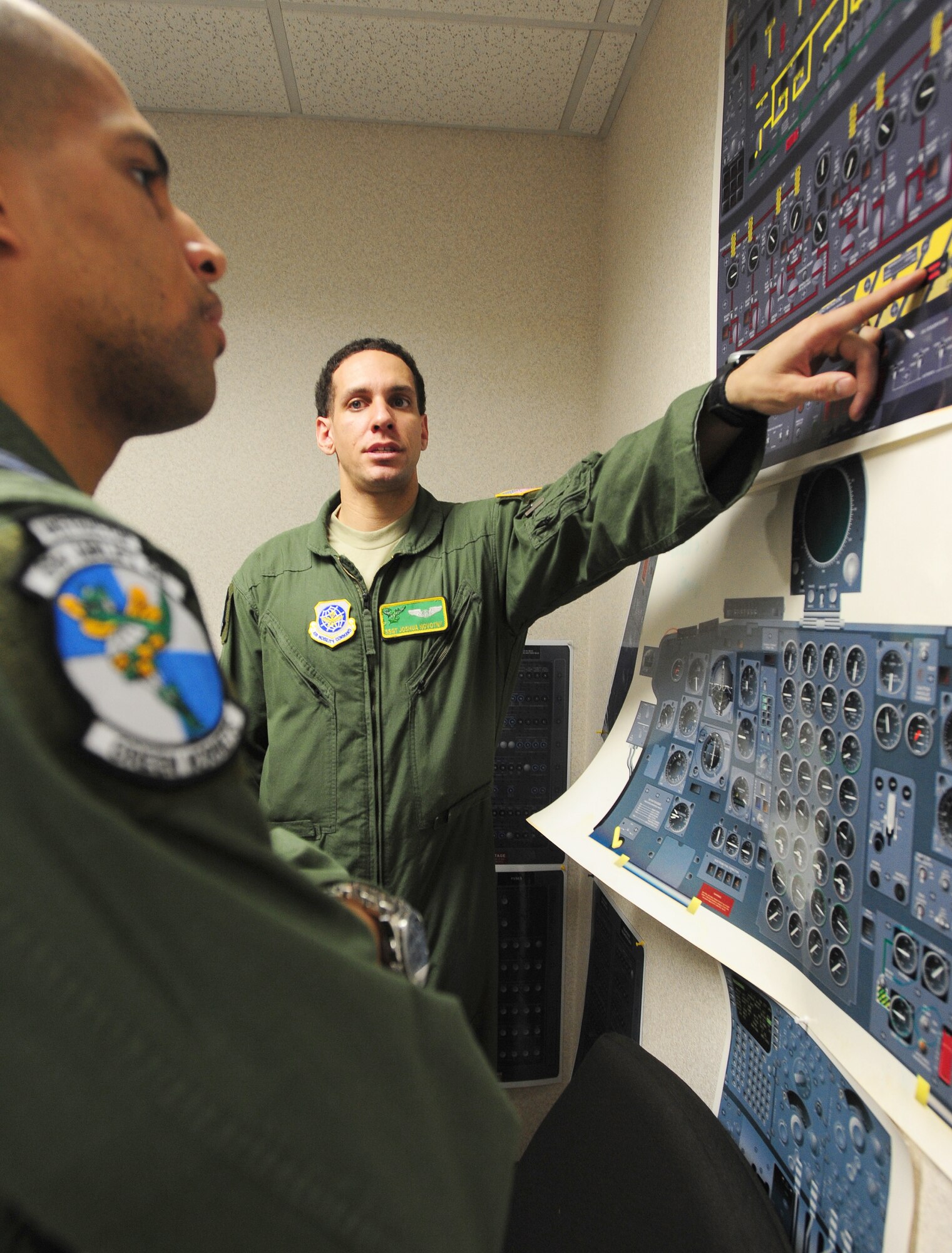 Staff Sgt. Joshua Novotny, 61st Airlift Squadron C-130E flight engineer, instructs an officer on C-130E and C-130H flight engineer controls Feb. 16 during training at the 61st Airlift Squadron. Sergeant Novotny presented exemplary ground duties which enabled on-time takeoffs and ensured delivery of supplies and evacuation of Haitian earthquake victims. (U.S. Air Force photo by Senior Airman Steele Britton)