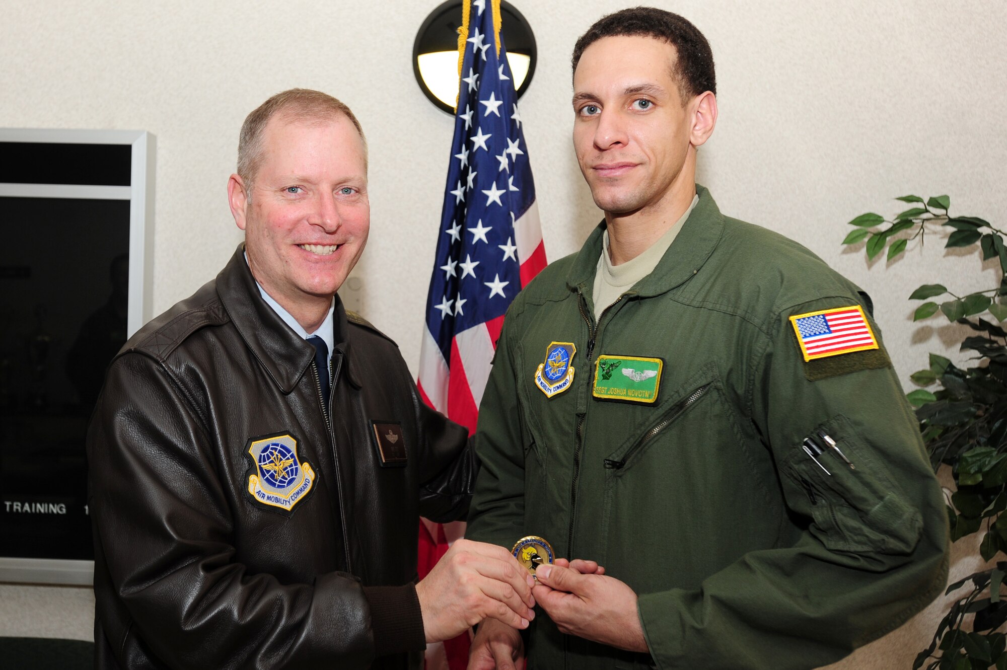 Col. Michael Zick, 19th Airlift Wing vice commander, presents a coin to Staff Sgt. Joshua Novotny, 61st Airlift Squadron C-130E flight engineer, for being selected as the Combat Airlifter of the Week. Sergeant Novotny’s aircraft carried a total of 174 passengers and delivered 44 tons of supplies in support of Operation Unified Response in Haiti. (U.S. Air Force photo by Senior Airman Steele Britton)