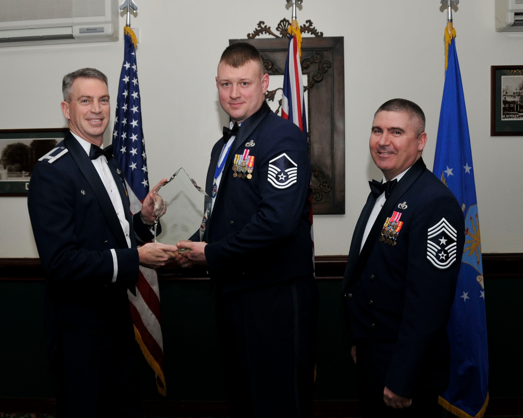 Col. Lawrence Reed, 48th Fighter Wing vice commander (left) and Chief Master Sgt. James Lucas present Master Sgt. Christopher P. Egbert,48th Equipment Maintenance Squadron, with the award for Military Volunteer of the Year at the annual awards at the Eagles Landing Feb 13. (U.S. Air Force photo by Airman 1st Class Eboni Knox)