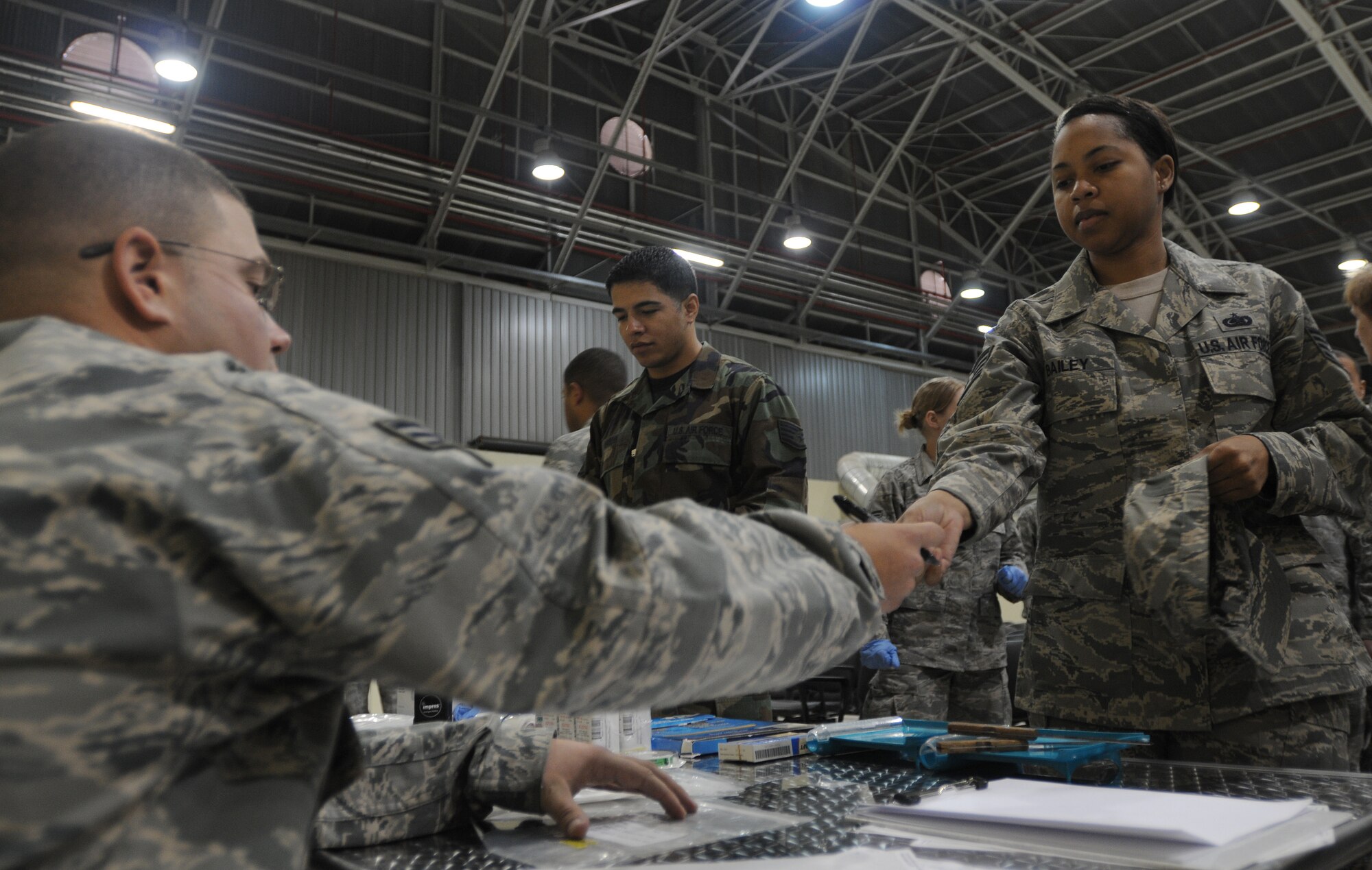 Senior Airman Mark Burger, 39th Medical Support Squadron, hands Staff Sgt. Quantesh Bailey, 39th Logistics Readiness Squadron, her identification card after checking her medical records to see how much medicine she will receive during a disease outbreak exercise Thursday, Feb. 11, 2010 on Incirlik Air Base, Turkey.  Airmen from the 39th Medical Group handed out preventative medicine to stop the spread of the disease during the exercise.  (U.S. Air Force photo/Senior Airman Ashley Wood)  