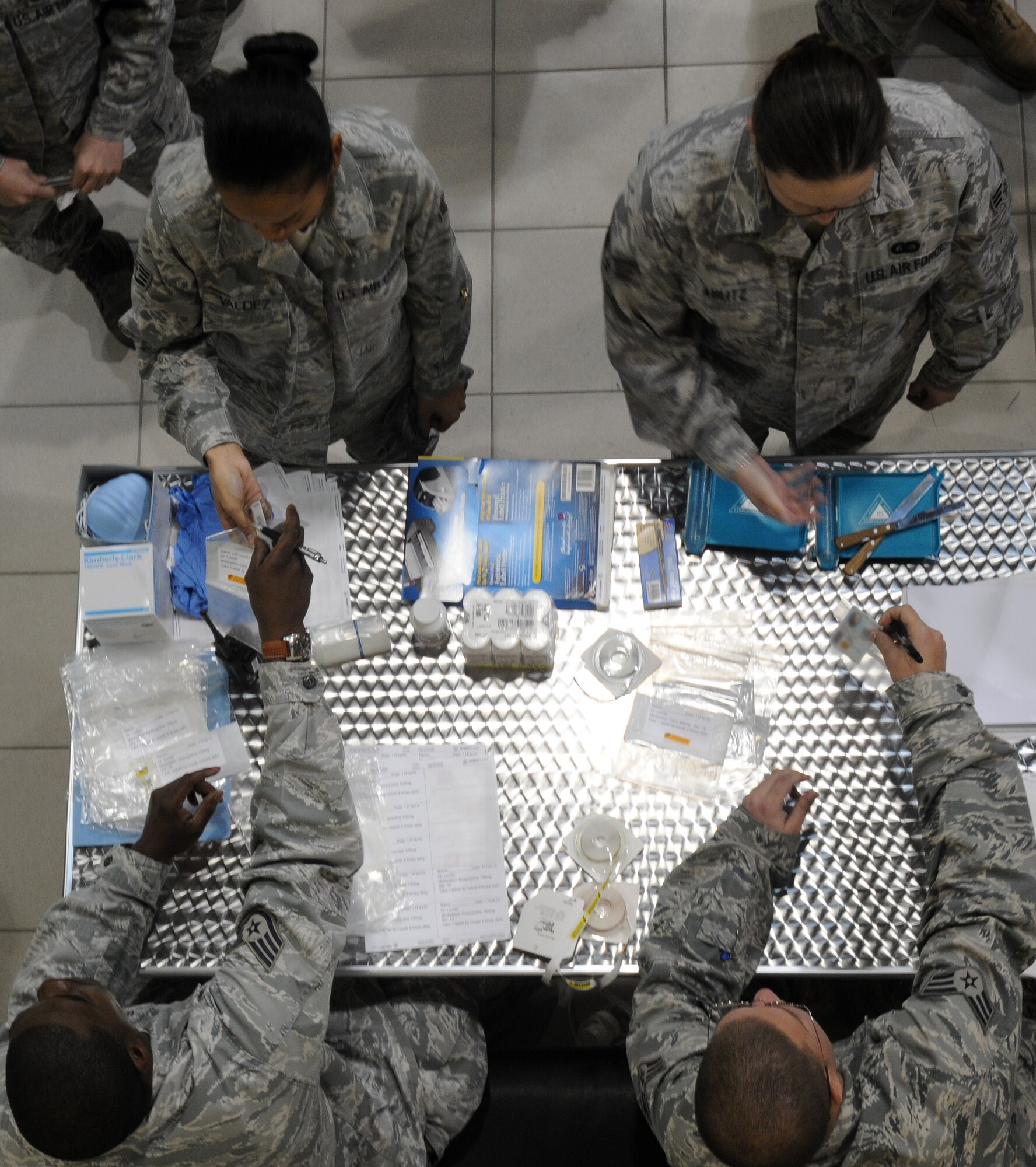 Senior Airman Mark Burger and Staff Sgt. Thurduras Piert, 39th Medical Support Squadron, take identification from Airmen to ensure they get the proper dose of medicine to prevent the spread of the pneumonic plague during a disease outbreak exercise Thursday, Feb. 11, 2010 on Incirlik Air Base, Turkey.  Exercises are held to ensure Airmen are mission ready in case of a real world crises.  (U.S. Air Force photo/Senior Airman Ashley Wood)  