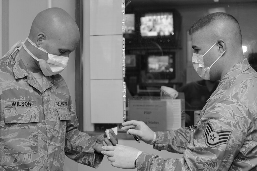 Staff Sgt. Andrew Shanks, 39th Medical Support Squadron, gives Staff Sgt. Andrew Wilson, 39th Force Support Squadron, a label to identify his medical file before being treated for a disease during a disease outbreak exercise Wednesday, Feb. 10, 2010 on Incirlik Air Base, Turkey.  This exercise was conducted to ensure Airmen know exactly what to do in case of a real world situation.  (U.S. Air Force photo/Senior Airman Ashley Wood)  