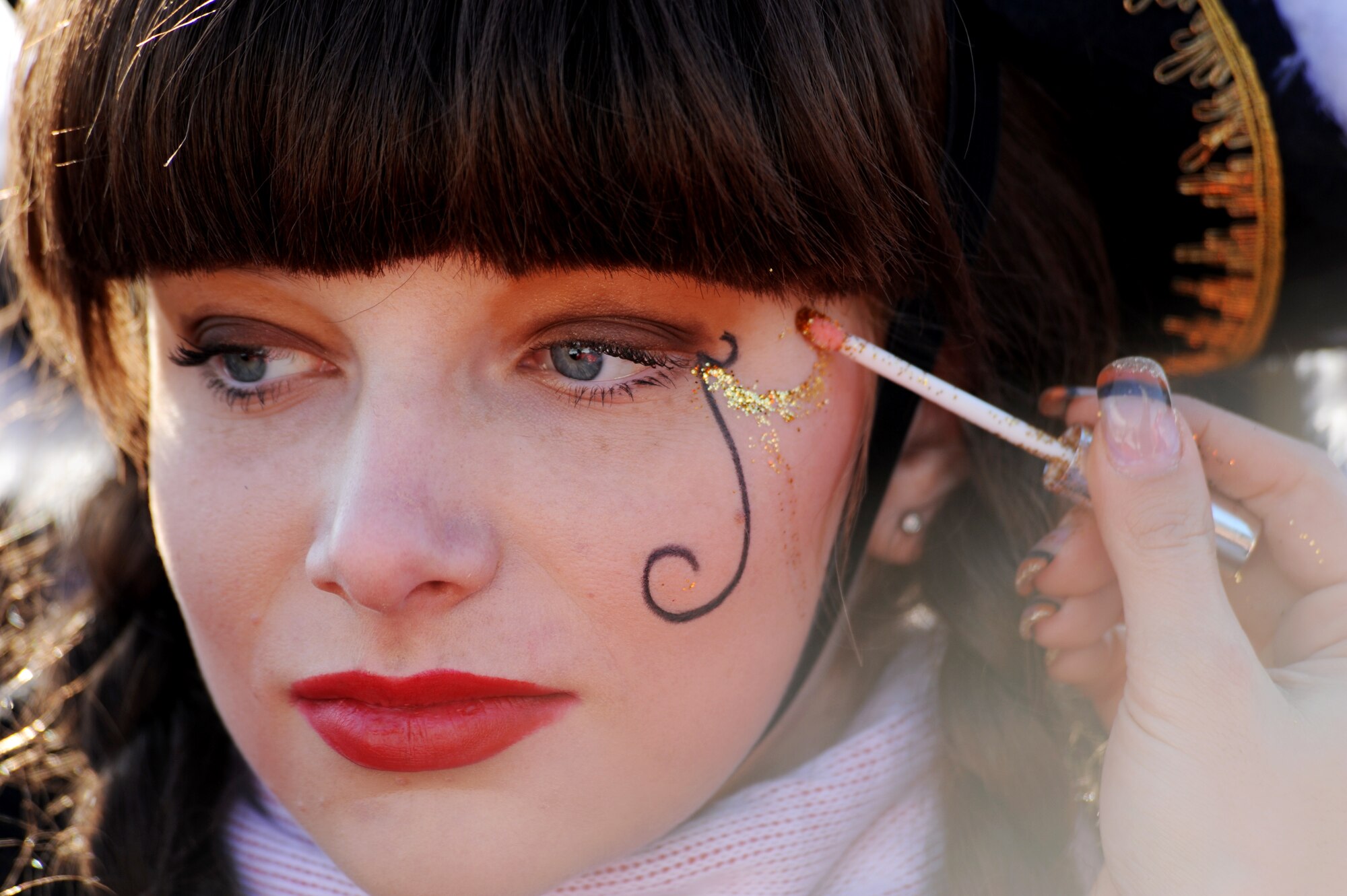 A local girl has her face painted prior to the Fasching parade in Ramstein village, Germany, Feb. 16, 2010. This annual event is a pre-Lenten carnival which is celebrated with the donning of wild and fancy costumes to chase away the evil spirits of winter in preparation for spring. (U.S. Air Force photo by Tech. Sgt. Sarayuth Pinthong)