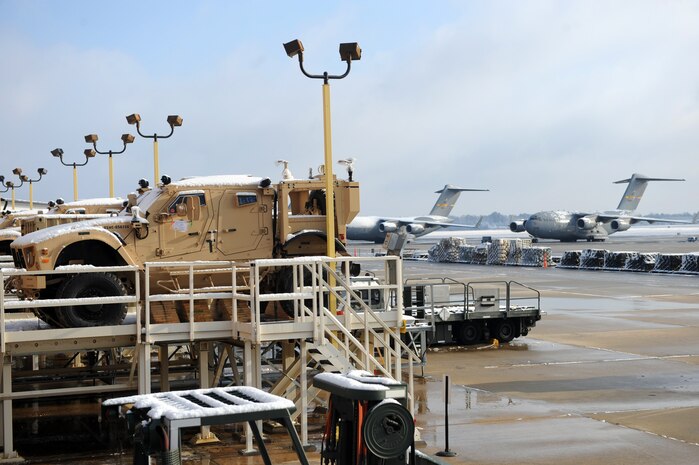 Mine-resistant, ambush-protected all-terrain vehicles and C-17 aircraft sit draped in snow on the flightline at Joint Base Charleston Feb. 13 after an overnight snowstorm delivered more than three inches of snow. According to base weather flight personnel, the storm was moderate at best, starting as rain, progressing to sleet and finally forming snow. The snowstorm was an uncommon event for the Charleston area, resulting in several delayed takeoffs due to the weather. (U.S. Air Force photo/Senior Airman Daniel Owen)
