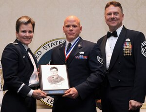 Col. Martha Meeker, left, and Chief Master Sgt. Mike Ivey, right, present Staff Sgt. James Hubby with the John L. Levitow Award during the Airman Leadership School Class 10-B graduation at the Charleston Club here Feb. 11. The award is given for a student's exemplary demonstration of excellence both as a leader and a scholar. Colonel Meeker is the 628th Air Base Wing commander, Chief Ivey is the 628th Air Base Wing command chief and Sergeant Hubby is a financial advisor with the 628th Comptroller Squadron. (U.S. Air Force photo/Senior Airman Katie Geiratz)
