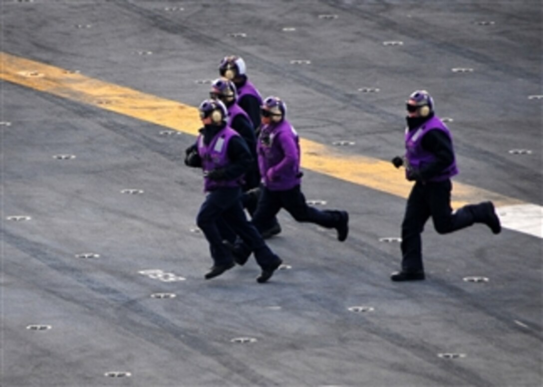 U.S. Navy sailors from the boatswain's mate fuel department run across the flight deck of the aircraft carrier USS Carl Vinson (CVN 70) during flight operations while at sea on Feb. 3, 2010.  The Carl Vinson is participating in Southern Seas 2010 as part of a home port shift.  