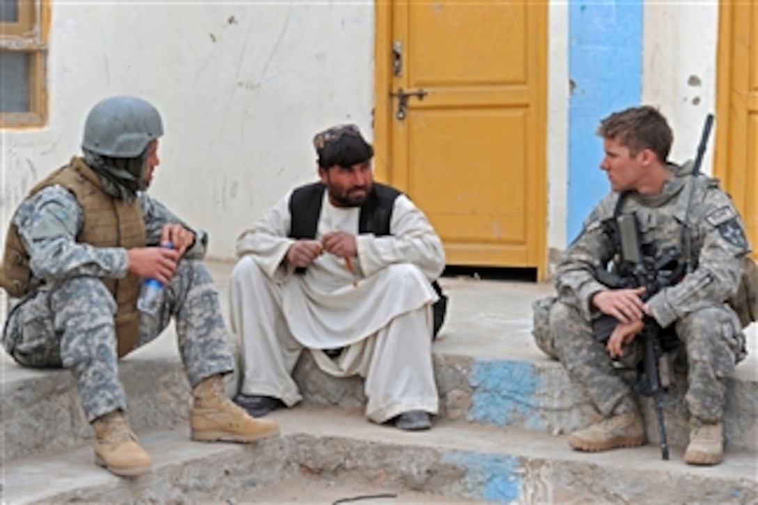 U.S. Army 1st Lt. David J. Leydet and his interpreter, with Bear Troop, 8th Squadron, 1st Cavalry Regiment meet with a school teacher during an inspection of his facilities in Hassanzai, Afghanistan, on Jan. 21, 2010.  