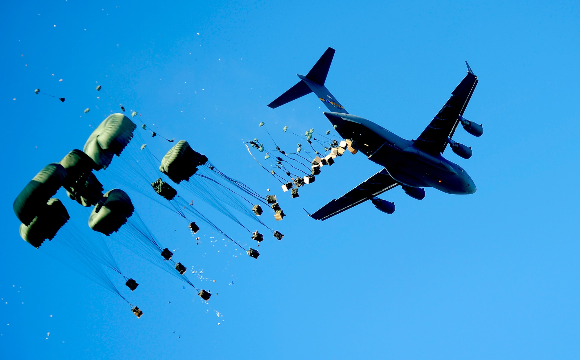 A U.S. Air Force C-17 Globemaster III aircraft drops pallets of water and food over Mirebalais, Haiti, Jan. 21, 2010, to be distributed by members of the United Nations.  Department of Defense assets have been deployed to assist in the Haiti relief effort following a 7.0 magnitude earthquake that that struck the country Jan. 12, 2010.  The aircraft is from the 437th Air Wing out of Charleston Air Force Base, S.C. (DoD photo by Tech. Sgt. James L. Harper Jr., U.S. Air Force/Released) 
