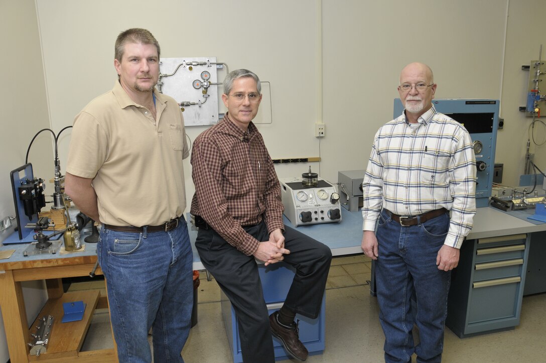 From left, Arnold Engineering Development Center’s Precision Measurement Equipment Laboratory (PMEL) Brad Pearson, Dale West and Gary Fergus stand in front of where coworker Michael Bunch was working when the 49-year instrument technician had a heart attack Feb. 11. Bunch survived due to the quick response of the three men and base EMTs, security and the dispensary’s nurse practitioner. (Photo by Rick Goodfriend)