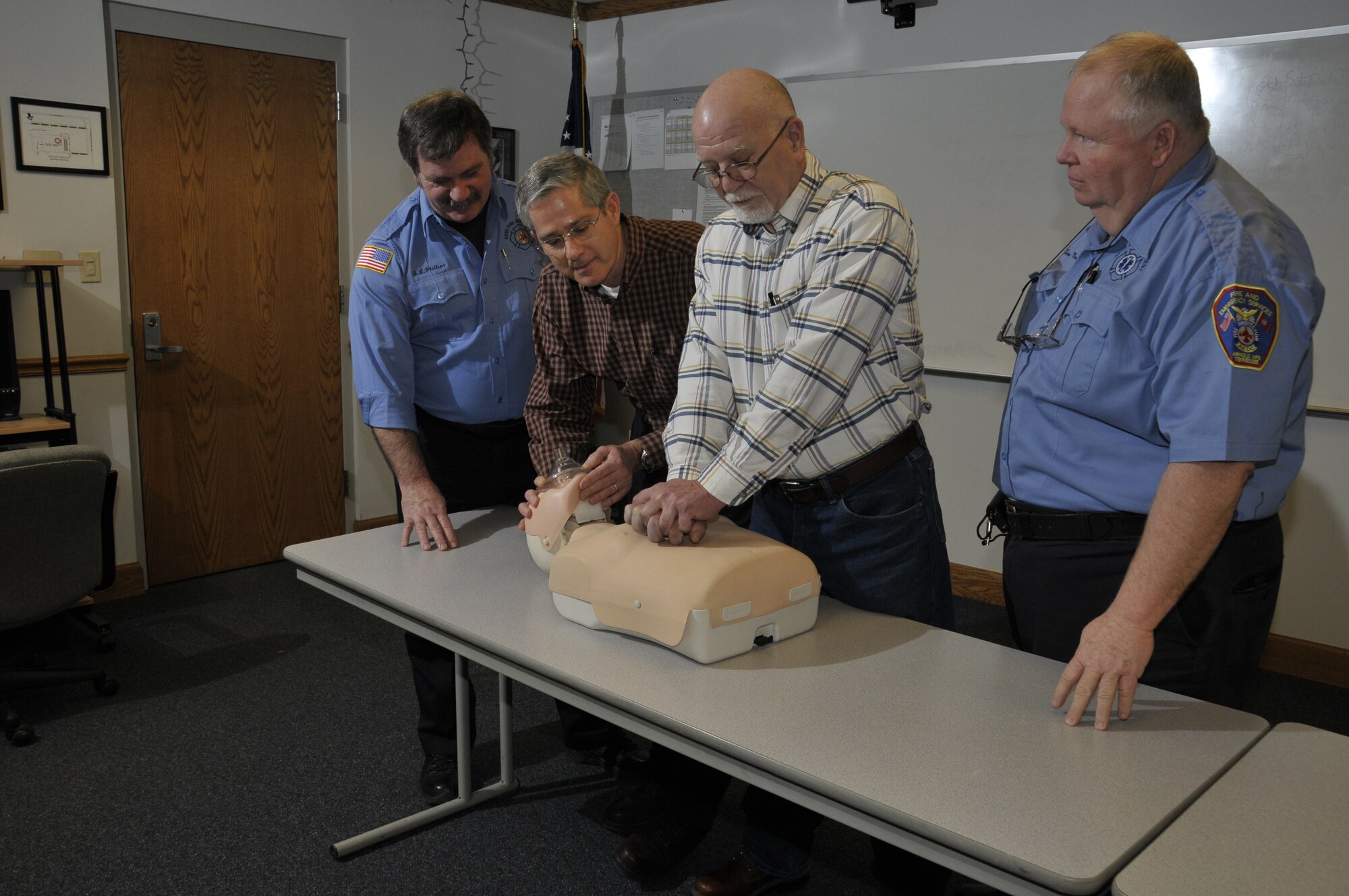 Far left and right Jim Phillips and Tim Mansfield, Aerospace Testing Alliance (ATA) paramedics with the Arnold Engineering Development Center Fire Department, watch as Precision Measurement Equipment Laboratory’s Dale West and Gary Fergus demonstrate how they administered cardiopulmonary resuscitation (CPR) to a coworker, Michael Bunch, Feb. 11. Phillips and Mansfield were the two EMTs who responded to the 911 call placed that day by Brad Pearson, an ATA instrument technician in the lab. Mansfield is also a CPR instructor on base. Doctors told Bunch he should be able to return to work in about three weeks. (Photo by Rick Goodfriend)