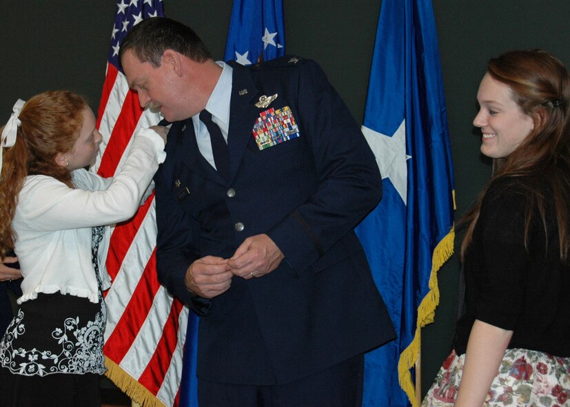Lilah Robison proudly pins on a new rank insignia for her father, Air Force Reserve Col. James Robison, Detachment 2, 919th Operations Group commander, during his promotion ceremony Feb. 17 at Hurlburt Field, Fla., as his eldest daughter Shelby observes.  The newly promoted colonel's unit is a subordinate organization of Duke Field's 919th Special Operations Wing. (U.S. Air Force photo/Dan Neely)