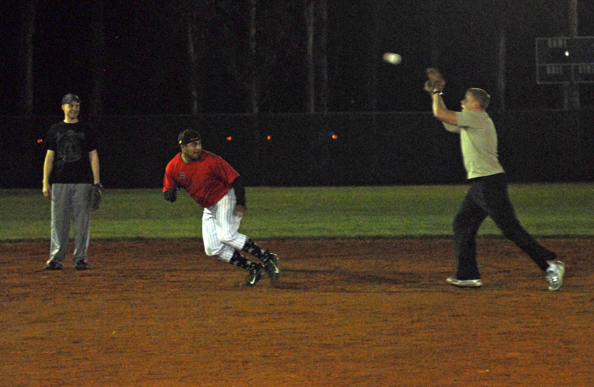 VANDENBERG AIR FORCE BASE, Calif. -- Attempting to steal third base, Jon Terrones, a team member of the Army Prison Guards, pulls a fast one on opposing team members of the 30th Space Communications Squadron during a winter intramural softball practice game at the base softball field here Tuesday, Feb. 16, 2010. Winter intramural softball season runs January through March. (U.S. Air Force photo/Airman 1st Class Kerelin Molina)