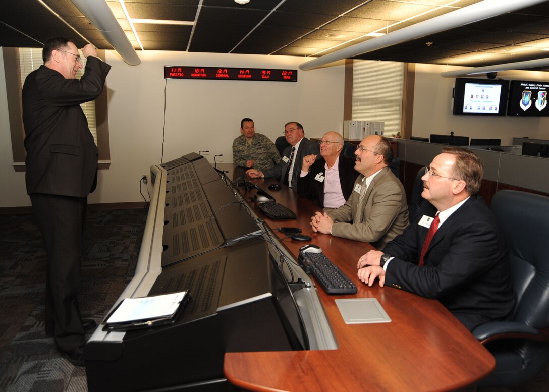 SCOTT AIR FORCE BASE, Ill. -- Dan Fri (left), Deputy Director for the 635th Supply Chain Management Wing, gives a brief on the capabilities of the Supply Chain Control Center to (front to back) Mayor Scott Abner, Mayor Jim Vernier, Mayor Gary Graham, Mayor Jerry Daugherty and Col Jeff Sick. (U.S. Air Force Photo by Airman 1st Class Tristin English)