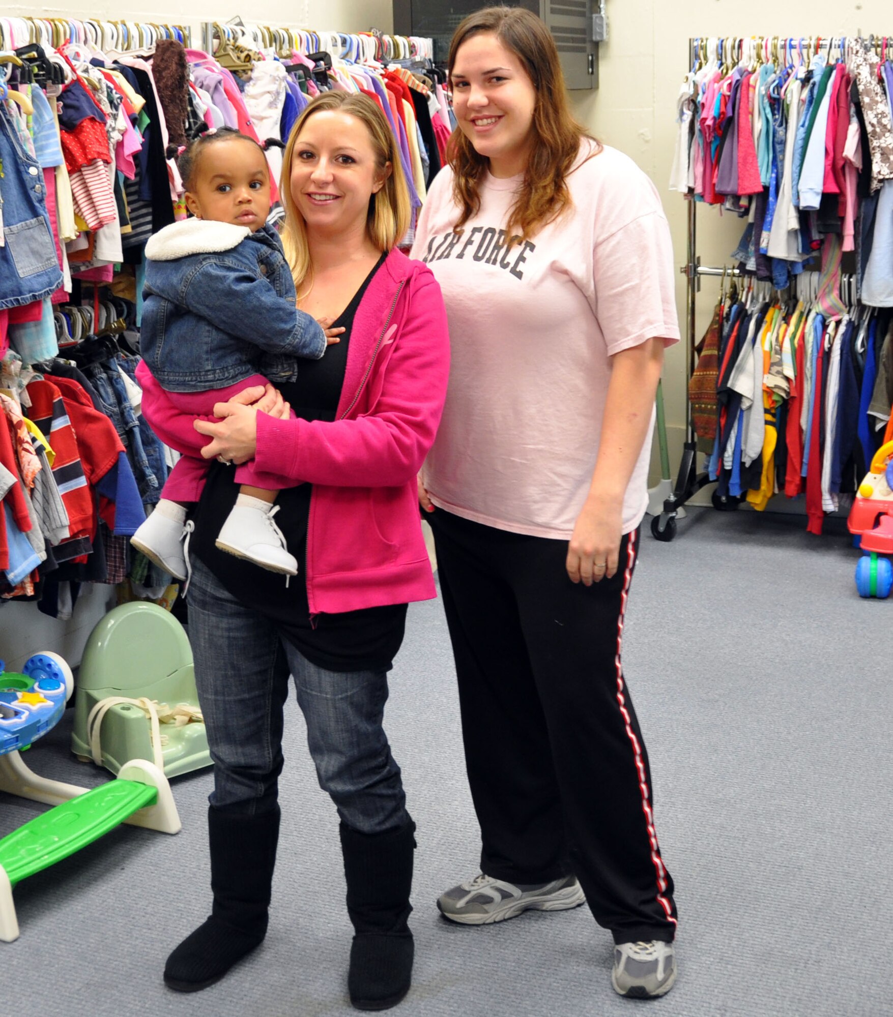 Joleen McBee, (right), manager, along with volunteer Carolyn Norman, help one of thier youngest customers shop for clothing. (U.S. Air Force photo/Amn Michael Battles)