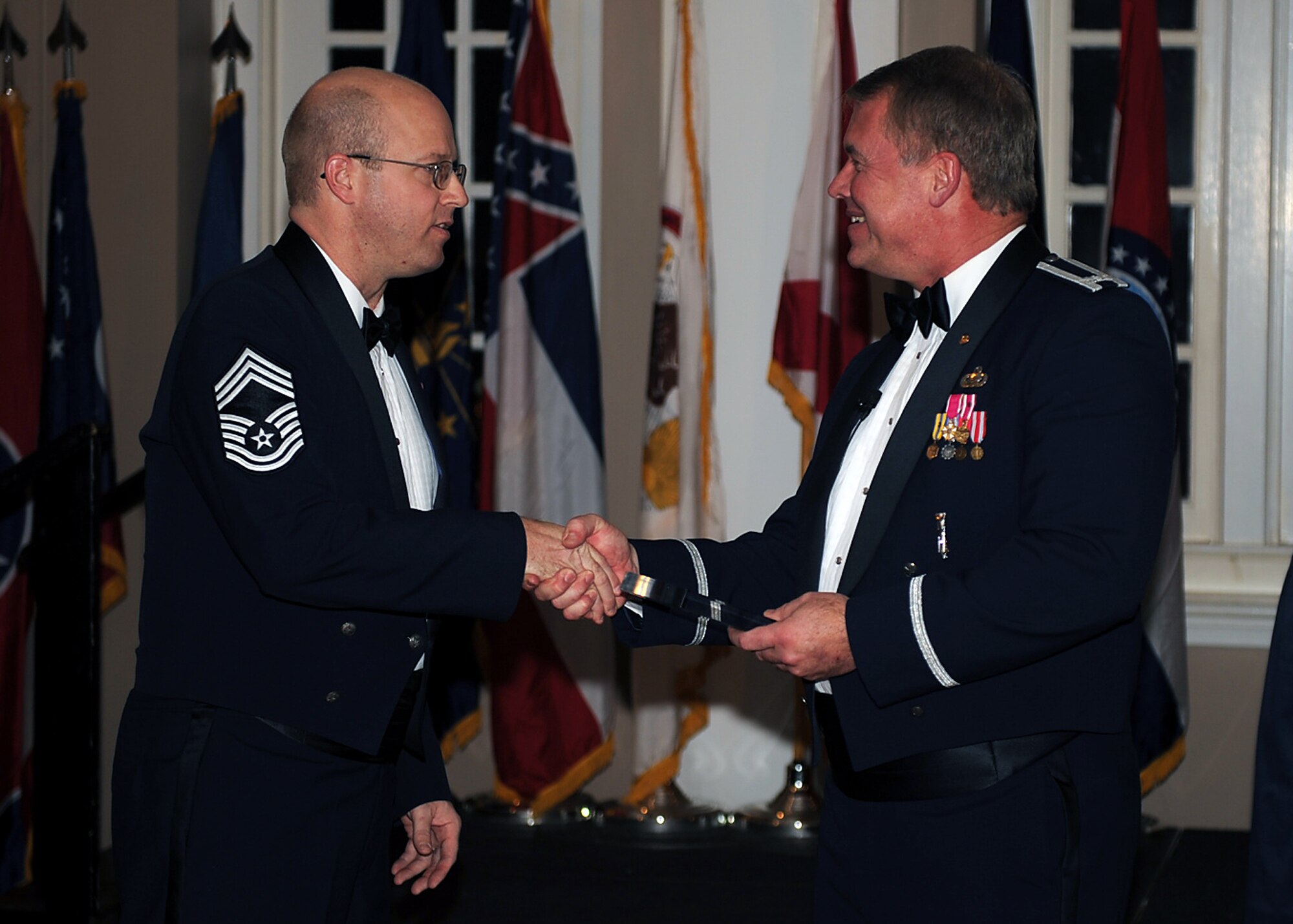 Chief Master Sgt. Todd Cole, 4th Operations Group superintendent, presents a plaque to retired Col. Douglas Carroll, 460th Space Wing director of staff, during a chief recognition ceremony at Seymour Johnson Air Force Base, N.C., Feb. 13, 2010. Carroll was the guest speaker for this year's ceremony and is the son of an original charter chief, Luther Carroll. Carroll is assigned to Buckley Air Force Base, Colo. (U.S. Air Force photo/Senior Airman Ciara Wymbs) 