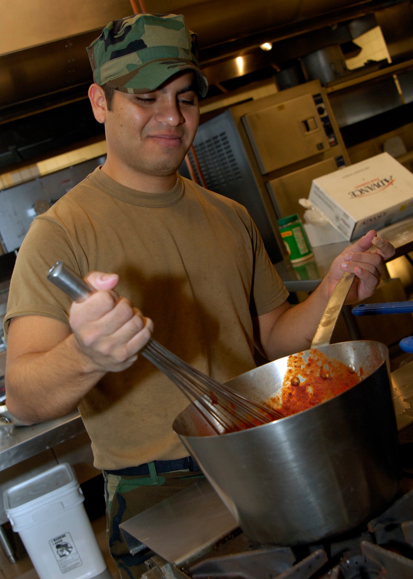 Navy Seaman Jose Alvarez, a culinary specialist, prepares spaghetti sauce in the food preparation area of the dining facility, Feb. 9, 2010, at McConnell Air Force Base, Kan.  DFAC staff members here train and certify members of sister services. (U.S. Air Force photo/Airman 1st Class Andrea Salazar)
