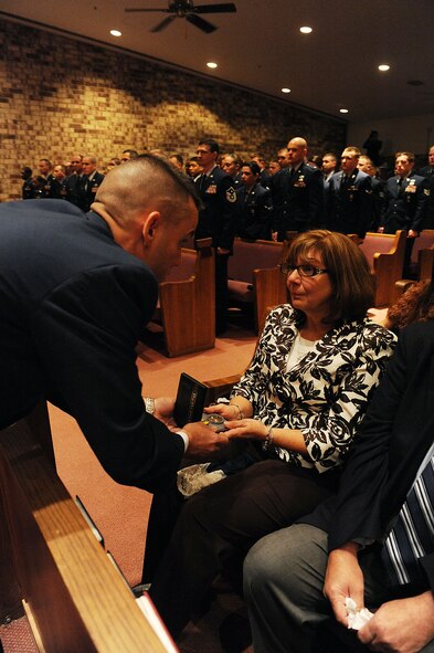 MOODY AIR FORCE BASE, Ga. -- Maj. Brint Woodruff, 824th Security Forces Squadron commander, presents Dorothy Horney, mother of Staff Sgt. David Horney, 824th SFS member, with an Air Force Commendation Medal here Feb. 13. (U.S. Air Force photo by Airman 1st Class Joshua Green)
