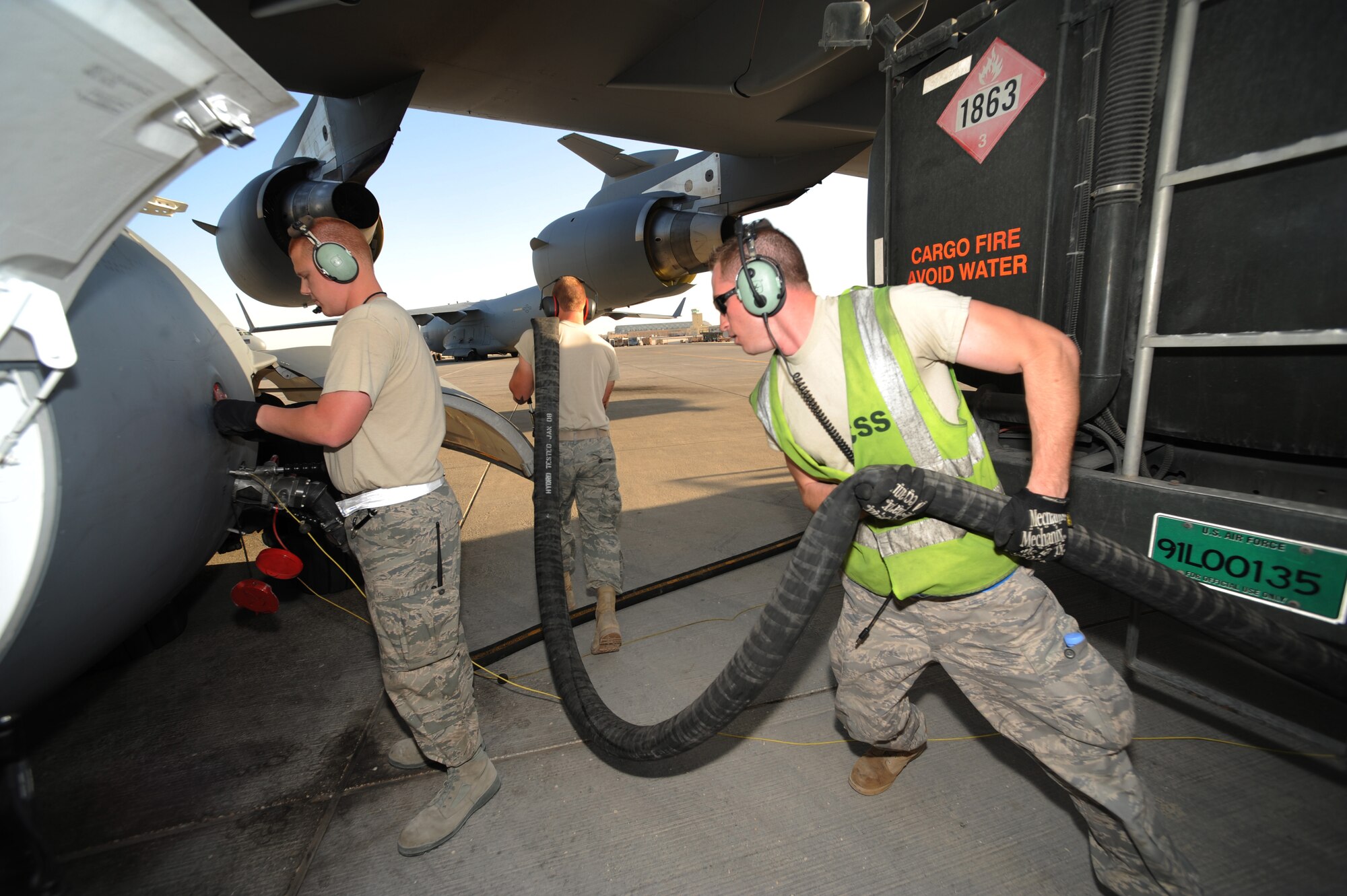 Staff Sgt. Devan Naughton, 8th Expeditionary Air Mobility Squadron communications and navigation craftsman, Senior Airman Samuel Schlatter, 8th Expeditionary Air Mobility Squadron auto flight controls and instruments journeyman, and Airman 1st Class Marcus A. Graf, 379th Expeditionary Logistics Readiness Squadron fuels distribution operator, prepare to refuel a C-17 Globemaster III at a non-disclosed Southwest Asia location, Feb 12, 2010. (U.S. Air Force photo by Tech. Sgt. Michelle Larche)[RELEASED]